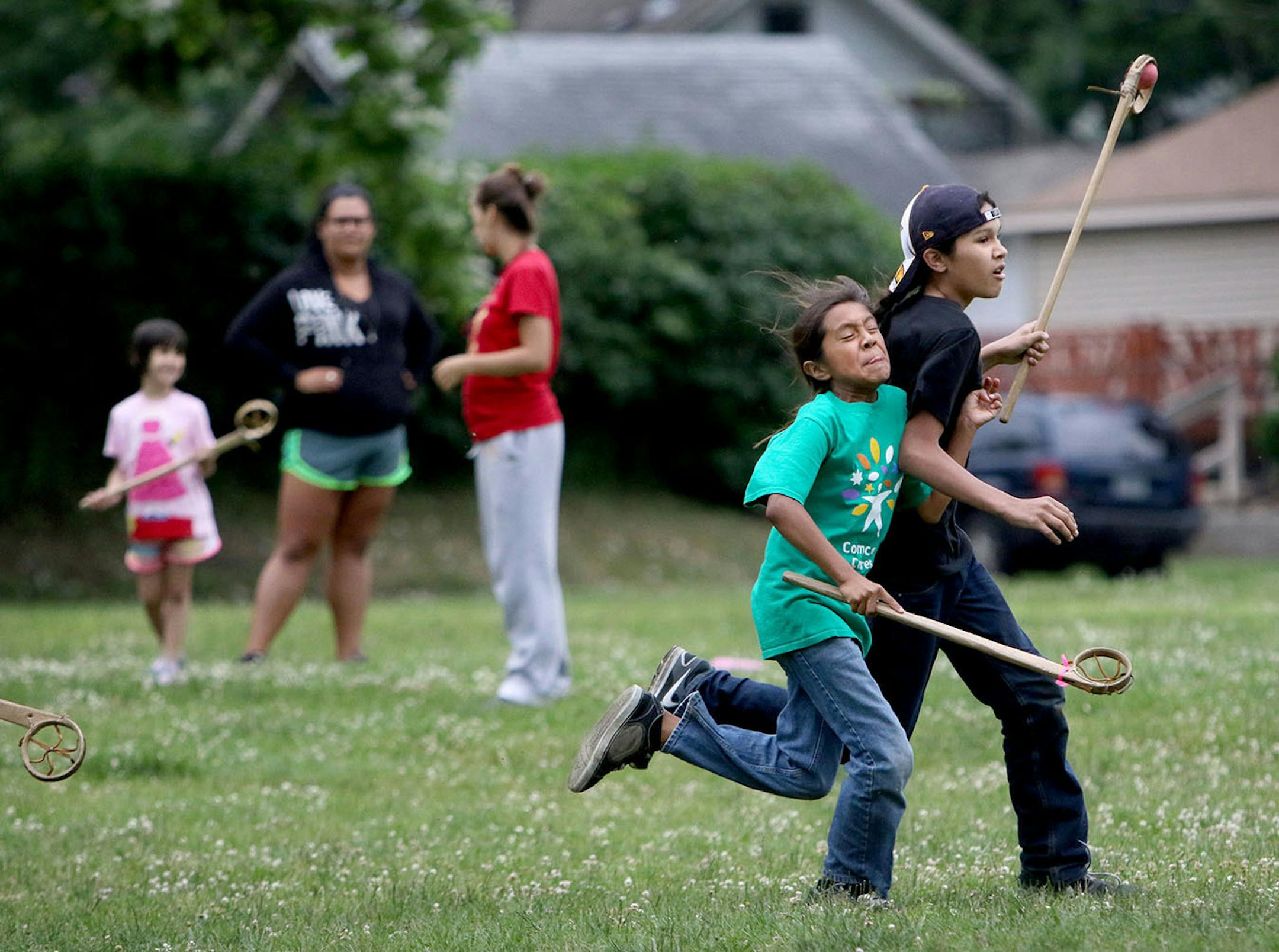 Youth boys team members of Twin Cities Native Lacrosse practice at Corcoran Park Wednesday, June 17, 2015, in Minneapolis, MN. The traditional Lacrosse players, who play with hand carved ash sticks, were preparing for the upcoming Twin Cities Native Lacrosse Tournament at the Osseo High School Saturday. Here, Santino DeCory, front left, collides with Bronson Grant while trying to defend Grant during a scrimmage.