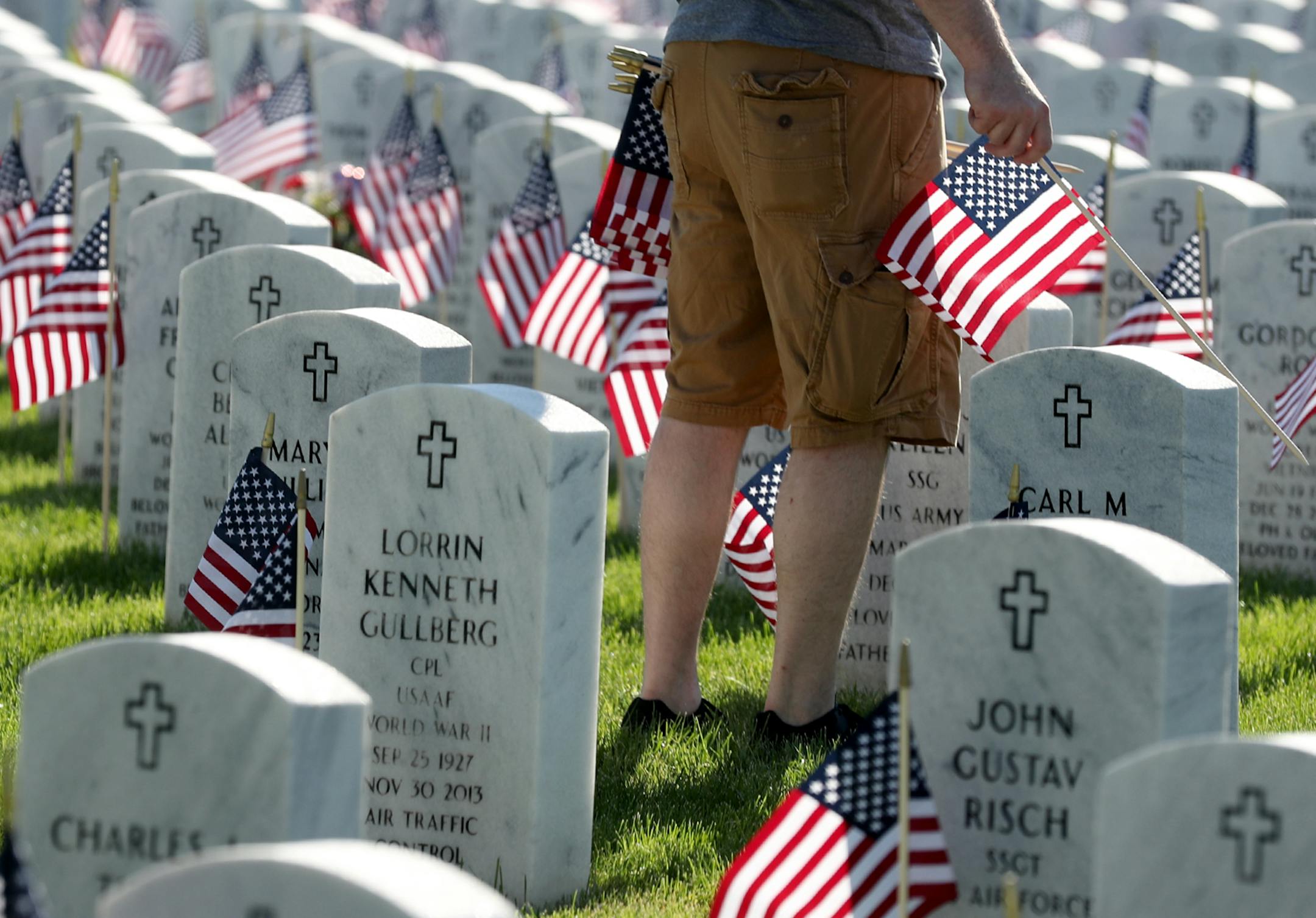 A volunteer plants American flags on the graves of soldiers for Memorial Day Saturday, May 26, 2018, at Fort Snelling National Cemetery in Bloomington, MN.] DAVID JOLES ï david.joles@startribune.com For the first time in 35 years, there will be a flag placed with every hero laid to rest at Fort Snelling National Cemetery for Memorial Day. That equals 200,000 flags!