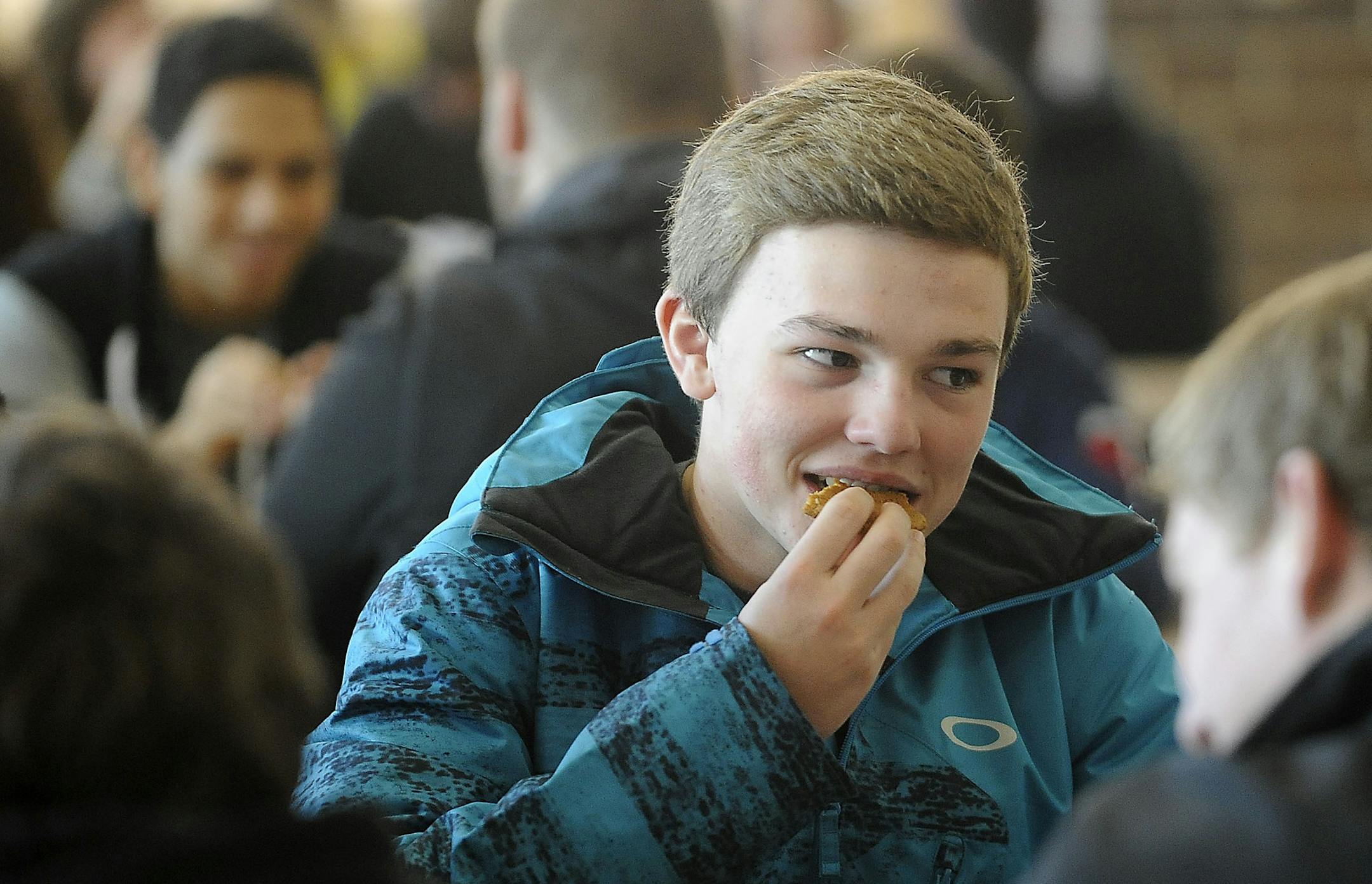 ADVANCE FOR MONDAY, FEB. 2 AND THEREAFTER - In a Friday, Jan. 23, 2015 photo, Dallas Appeldorn eats a chocolate chip cookie during lunch at Harrisburg High School in Harrisburg, S.D. Something is different about the lunch line's cookies this year at Harrisburg High School; they are healtheir. Schools across the United States were forced to meet health guidelines for snacks this year with the roll out of the federal Smart Snacks program. (AP Photo/Argus Leader, Emily Spartz)