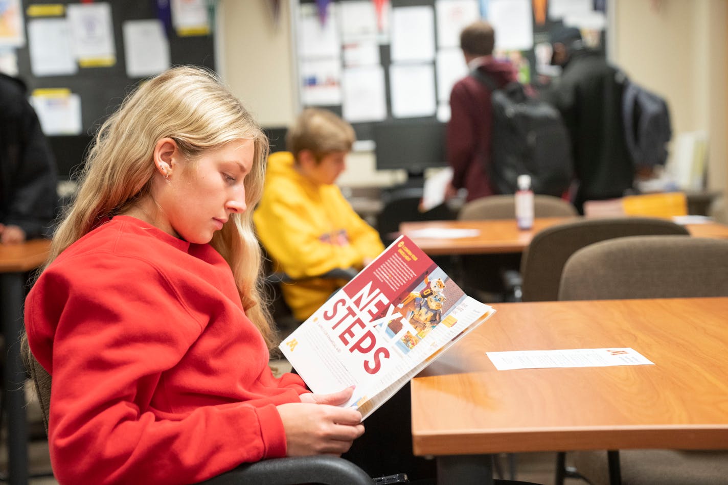 Anna DeMarre, a senior from Burnsville High School, reads an admissions guide during a presentation an admissions counselor from the University of Minnesota on Thursday, April 7, 2022.