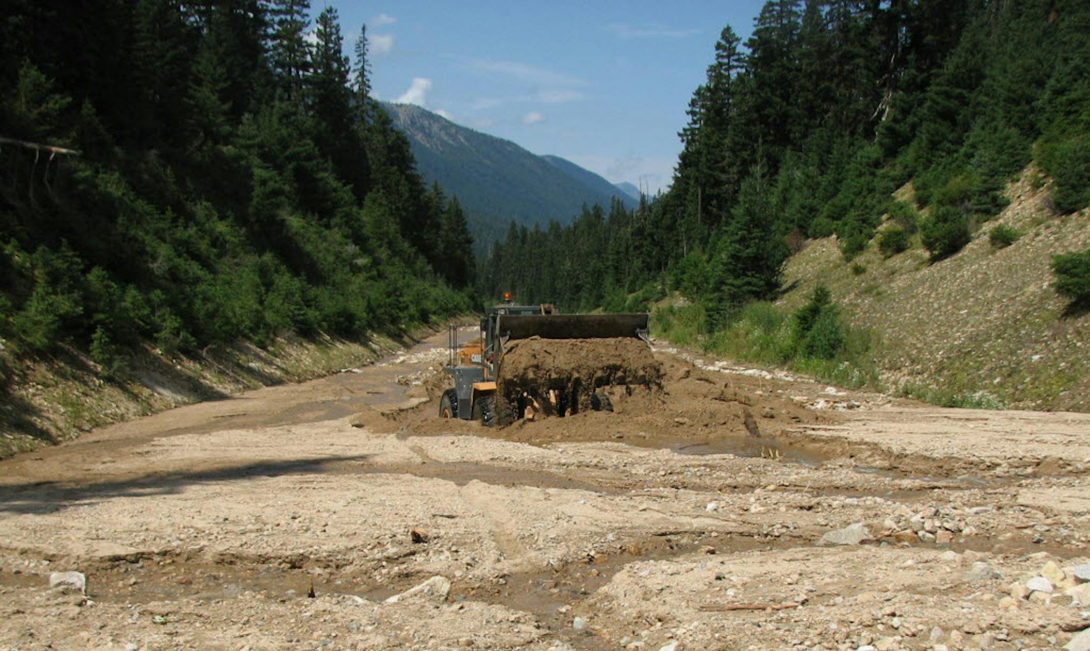 A front-end loader working to clear a massive mud and rock slide blocking Highway 20 in Washington state. The slide was one of several in the area this weekend, including one near Marblemount, Wash., that washed out a gravel road, stranding 65 hikers at the Cascade Pass Trailhead.