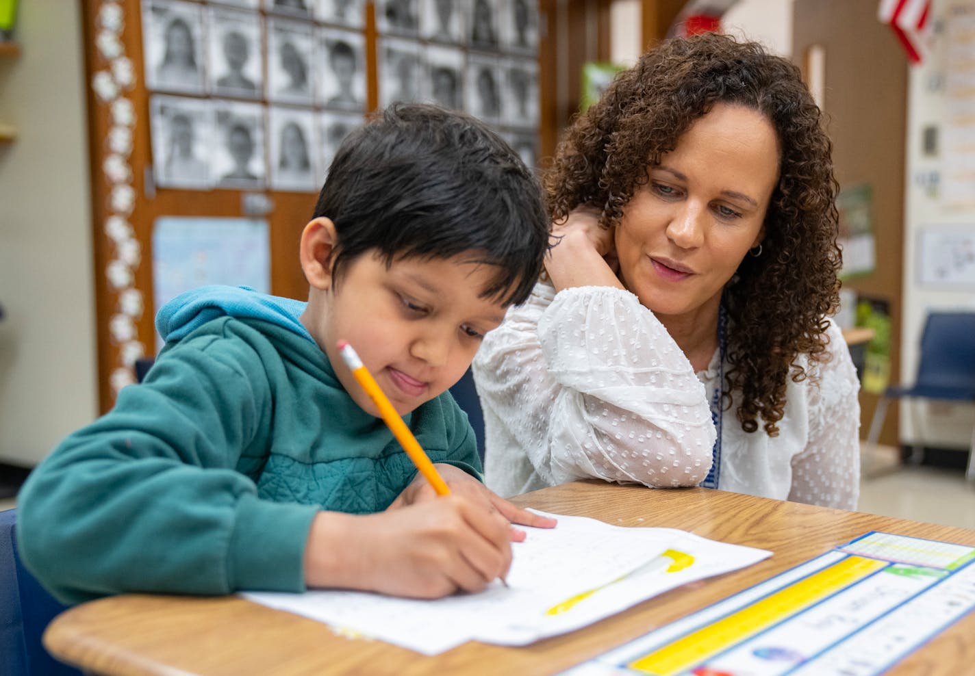 Shivam Roy practiced his writing and spelling while working with Principal Maria Roberts during a phonics lesson at Wilshire Park Elementary School in St. Anthony.