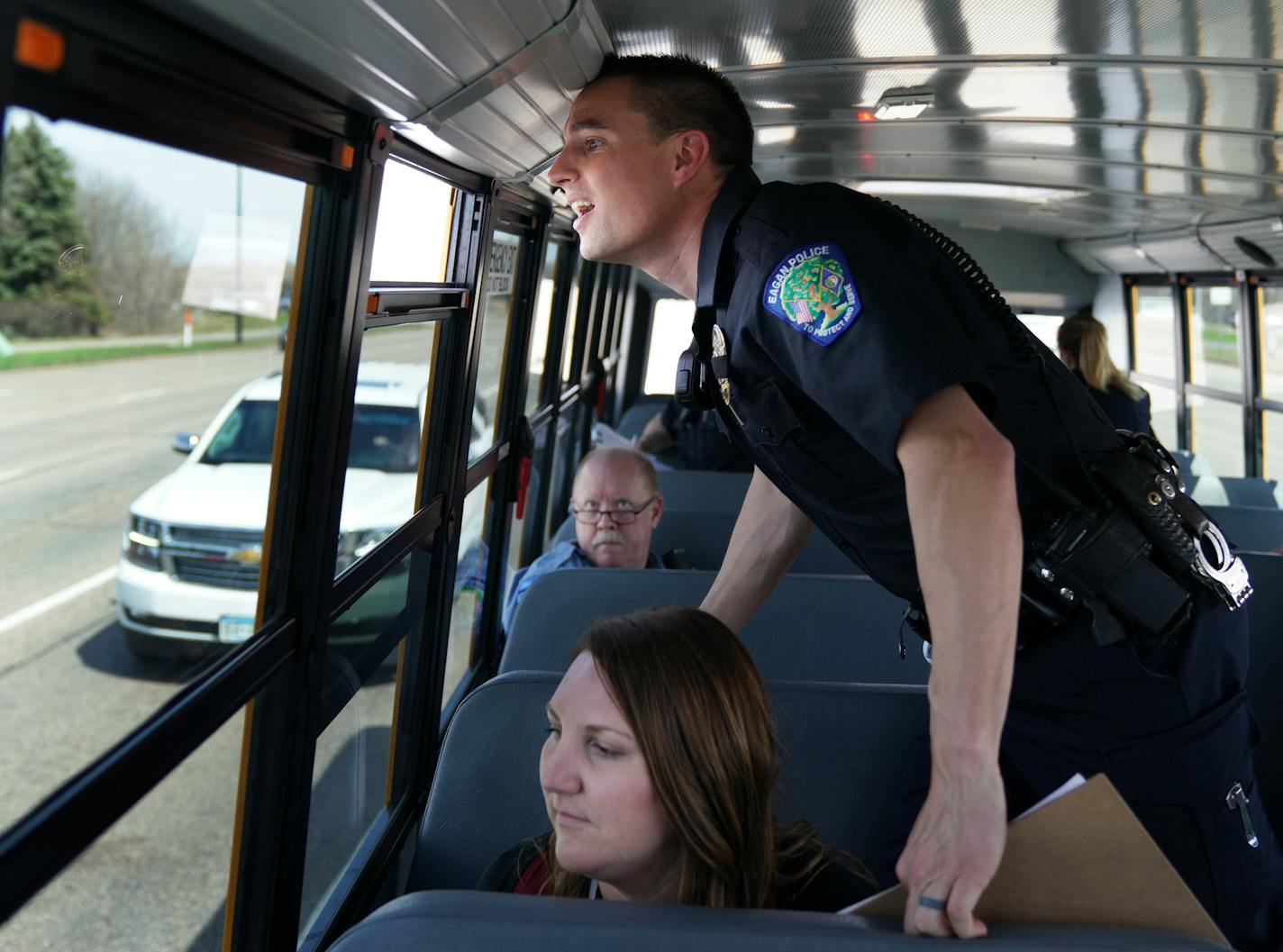 Eagan police officer Luke Nelson strained to get a better look at an offender as he and fellow officers rode a school bus looking for distracted driversduring Wednesday's "Busted by the Bus" initiative.