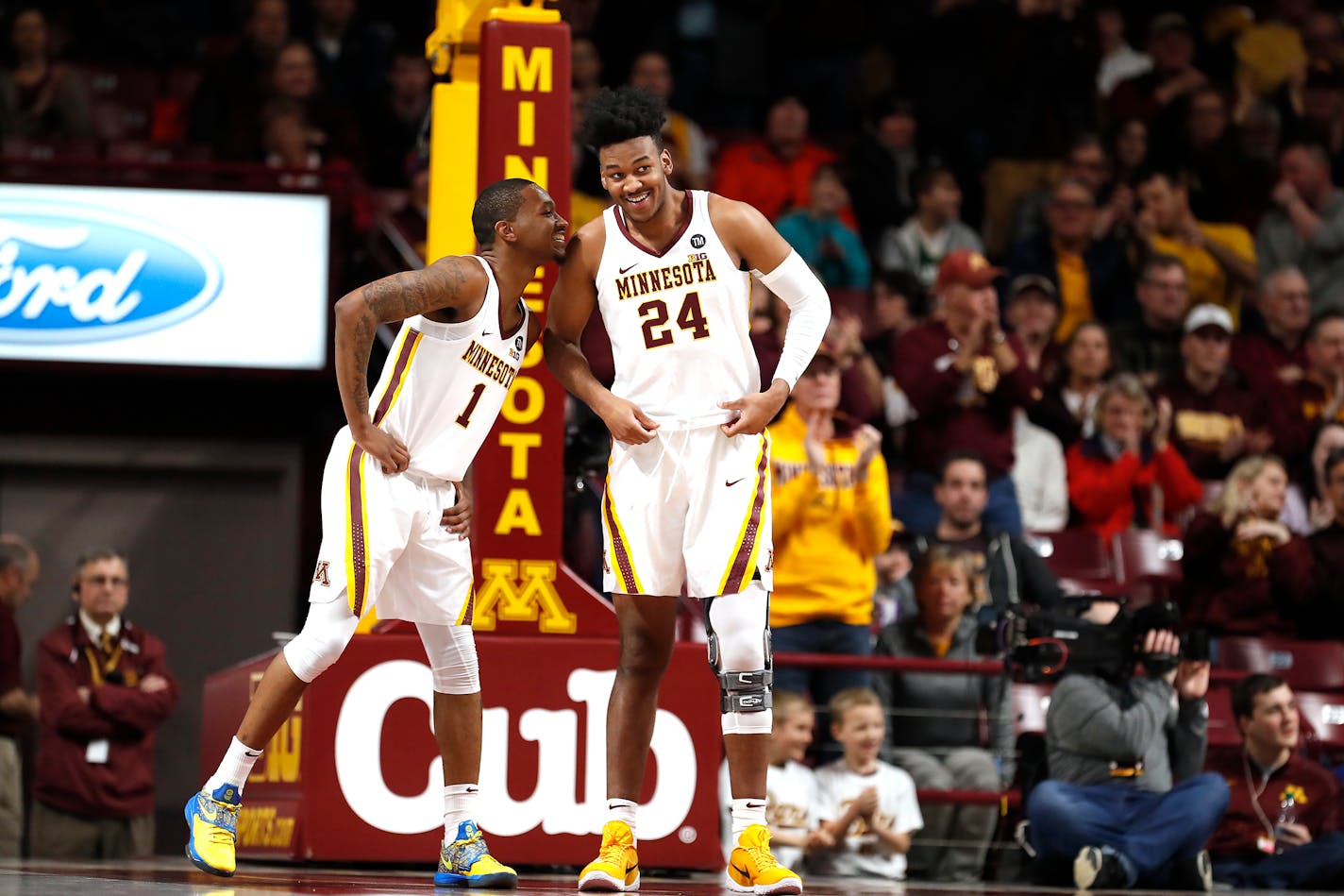 Gophrs forward Eric Curry (24) chats with Dupree McBrayer (1) just after entering the game during the first half.