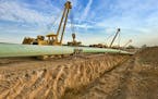 FILE -- A crew installs a section of a crude oil pipeline for Enbridge Energy. The Calgary-based pipeline company wants to build a new 337-mile pipeli