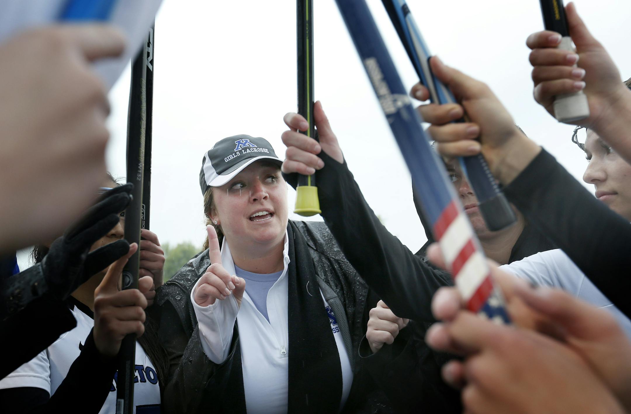 Minnetonka lacrosse coach Erin Scearcy Larson kept her team pumped up in a match against rival Wayzata, despite steady rain. (Carlos Gonzalez, Star Tribune)