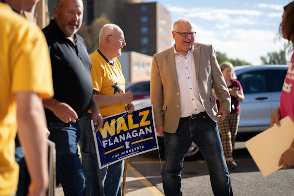 Gov. Tim Walz laughed at a comment by longtime supporter Lance Peterson, left, after the governor spoke at a rally at the Rochester DFL office on Sept