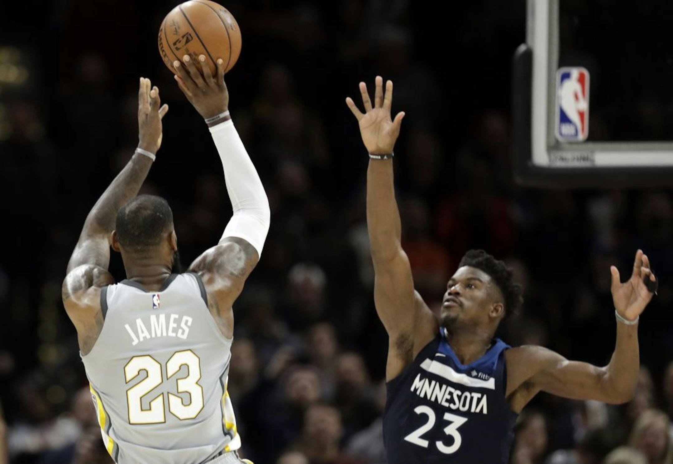 Cleveland Cavaliers' LeBron James, left, shoots over Minnesota Timberwolves' Jimmy Butler for the game-winning basket in overtime of an NBA basketball game, Wednesday, Feb. 7, 2018, in Cleveland. The Cavaliers won 140-138 in overtime.