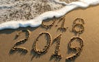 iStock
New year 2019 and old year 2018 written on sandy beach with waves.