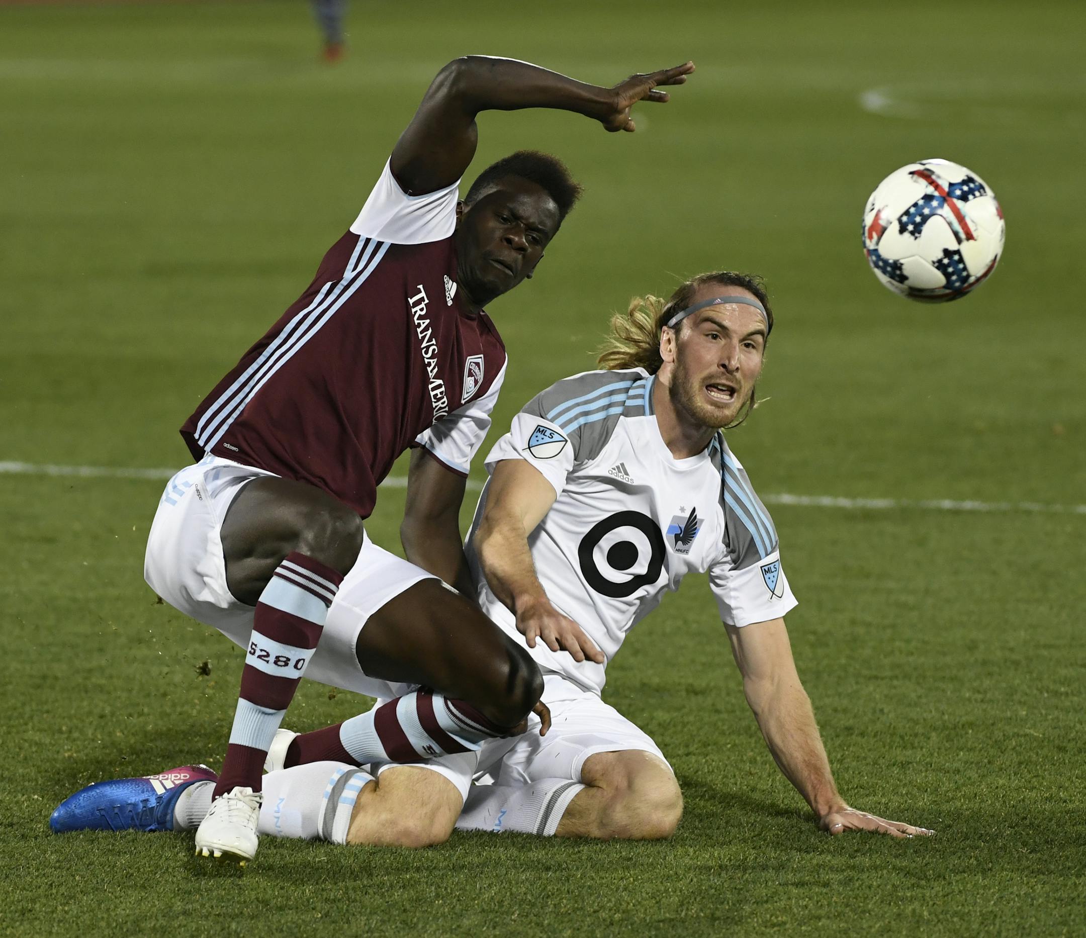 Colorado Rapids forward Dominique Badji, left, and Minnesota United defender Brent Kallman go after the ball during the first half of an MLS soccer match Saturday, March 18, 2017, in Commerce City, Colo. (Andy Cross/The Denver Post via AP)