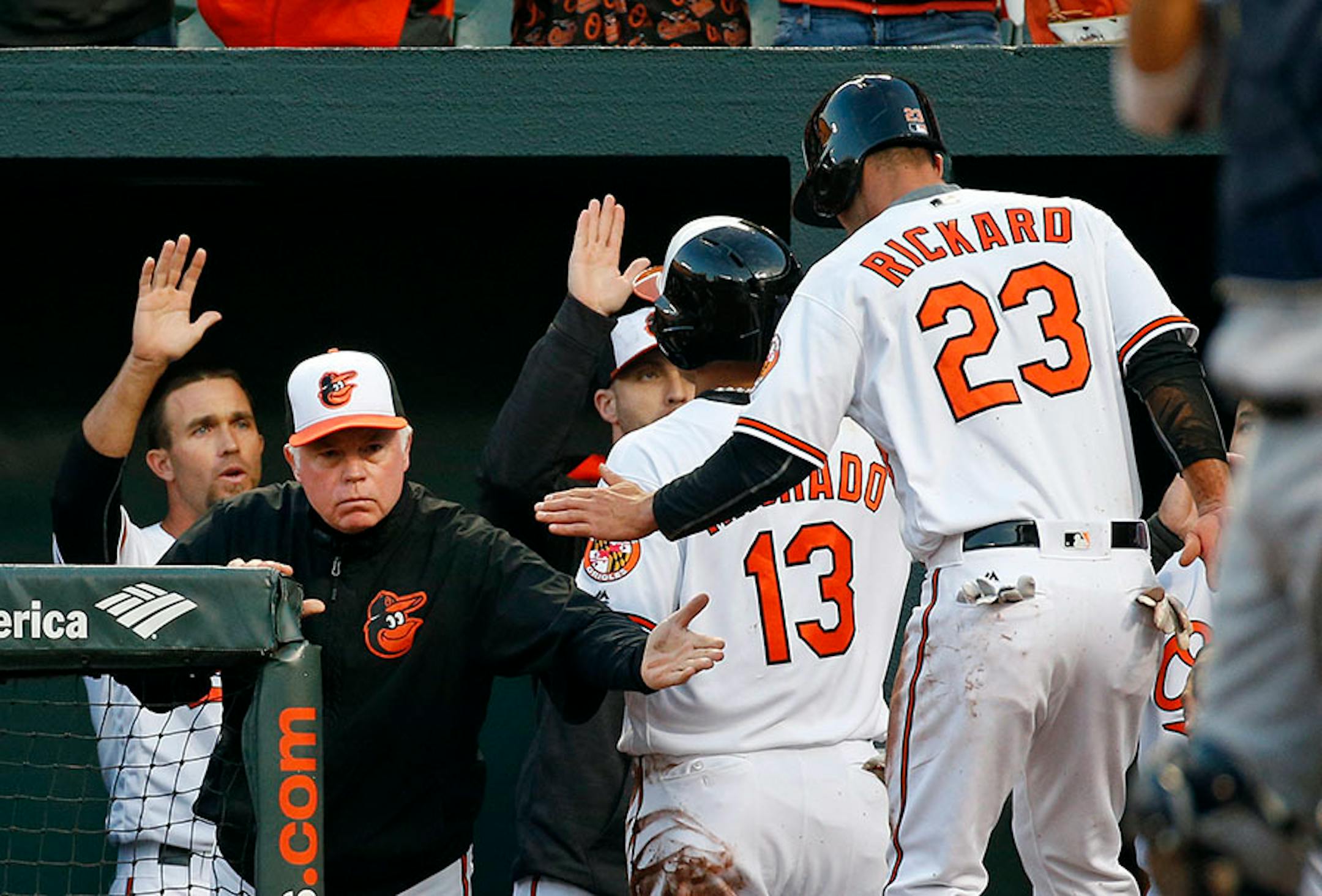 Baltimore Orioles manager Buck Showalter, left, high-fives Joey Rickard (23) after Rickard and Manny Machado (13) scored on a double by Adam Jones in the fifth inning of an opening day baseball game against the Minnesota Twins in Baltimore, Monday, April 4, 2016. (AP Photo/Patrick Semansky)