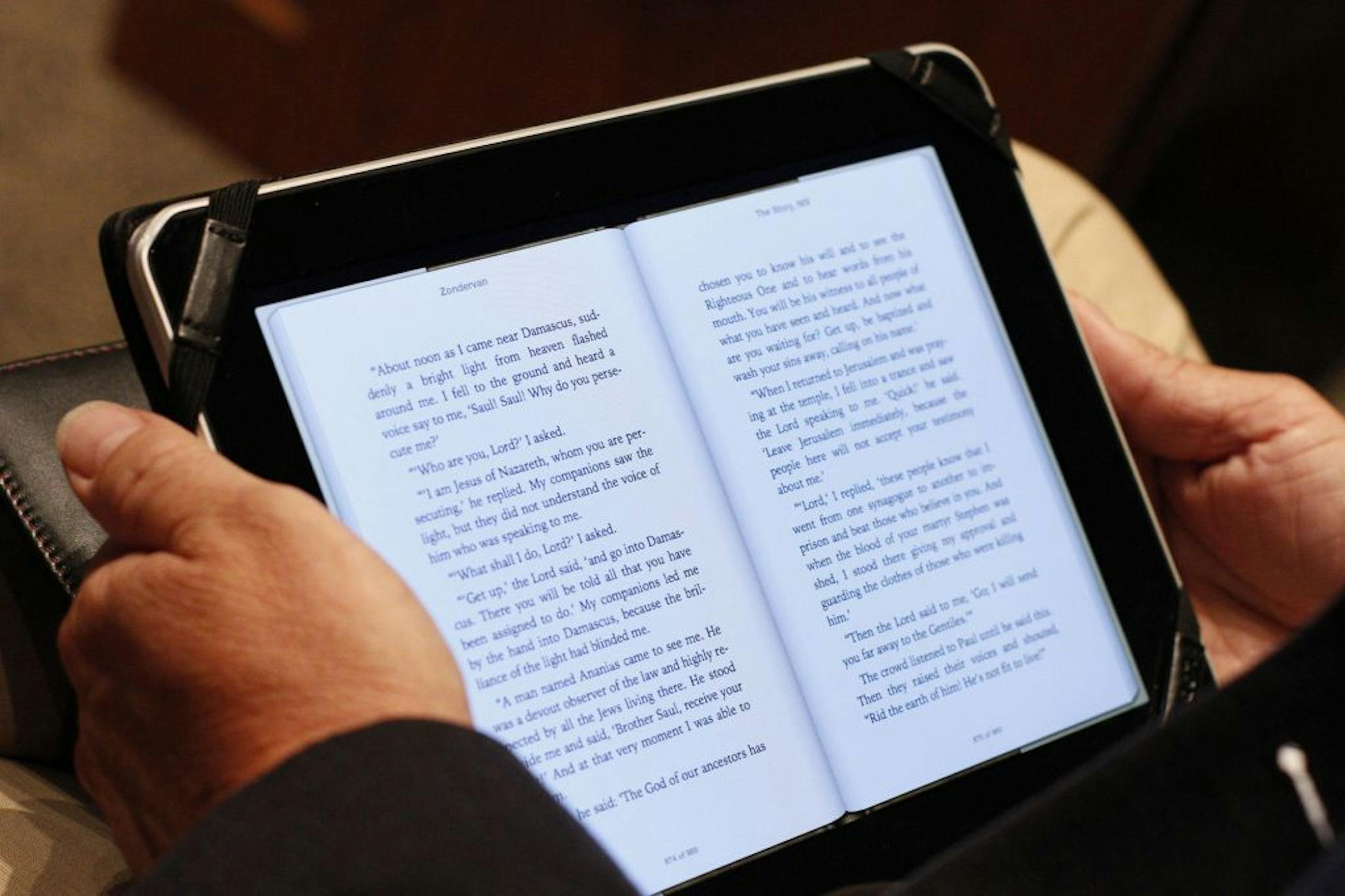 Bishop Roland Baker used his Bible app at Apostolic Church. Experts say the undisputed reign of the printed Bible may be over.