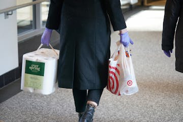 A rubber gloved shopper carried paper towels and other supplies through the downtown Minneapolis skyway.