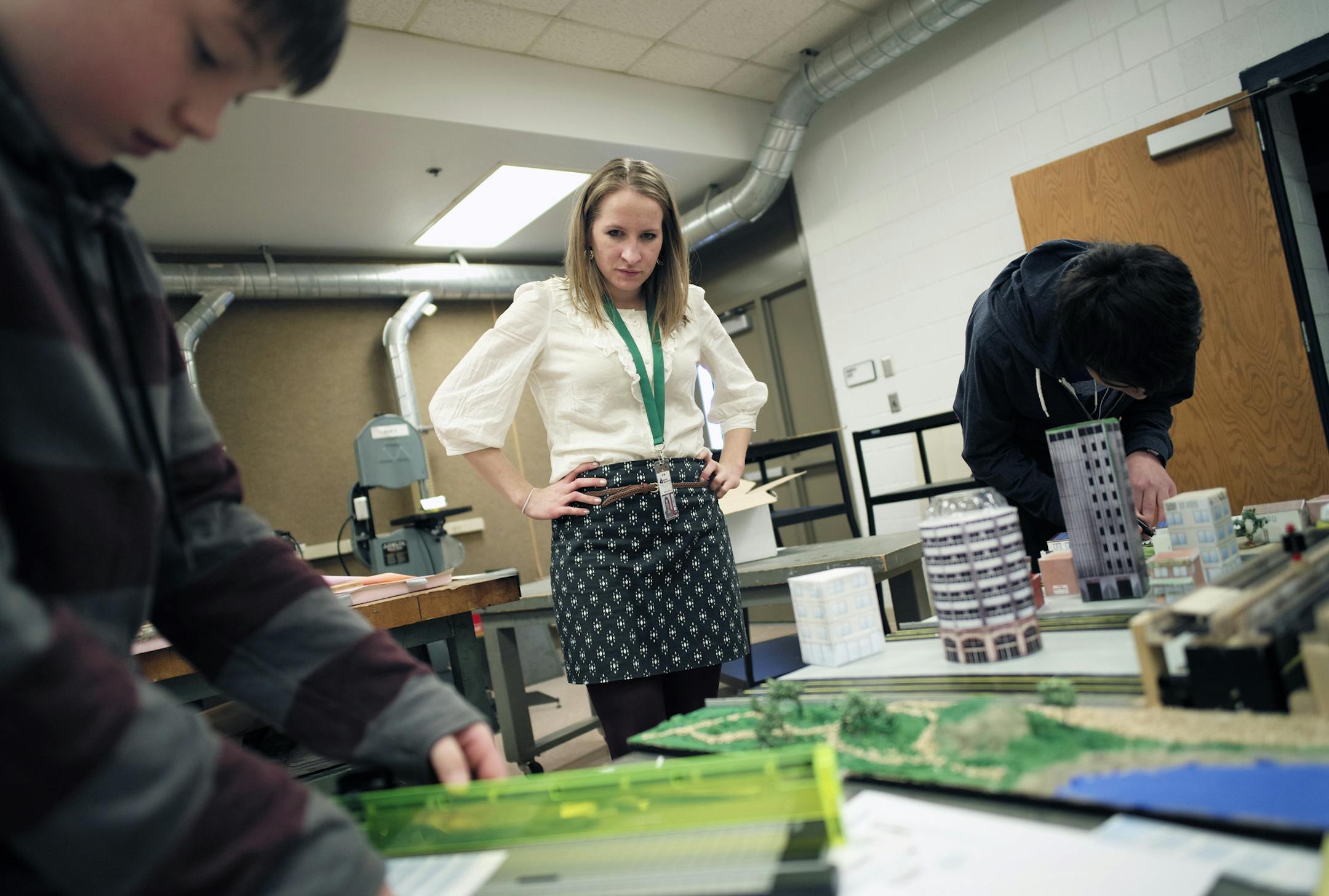 At Rosemount Middle School, teacher Alyssa Simmers overlooks "Awecity" with team members Will Rhoda,12, and Sam Vanderwiel, 13. The city is powered by solar and wind energy and features a maglev train. The competition asks students to solve global problems by designing their own vision of a city in the future. This year's focus is on transportation issues, and students use both Sim City software and real-world materials to design their model..]rtsong-taatarii@startribune.com
