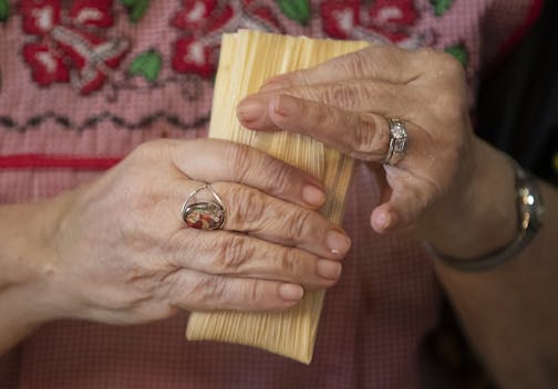 Retired St. Paul Public School teacher Rosemary Campos gave a quick lesson on how to fold the tamale before placing in pot. The former military veteran gathered with current and former school teachers for her yearly tamale making party at her home, Saturday, December 1, 2018 in St. Paul, MN.