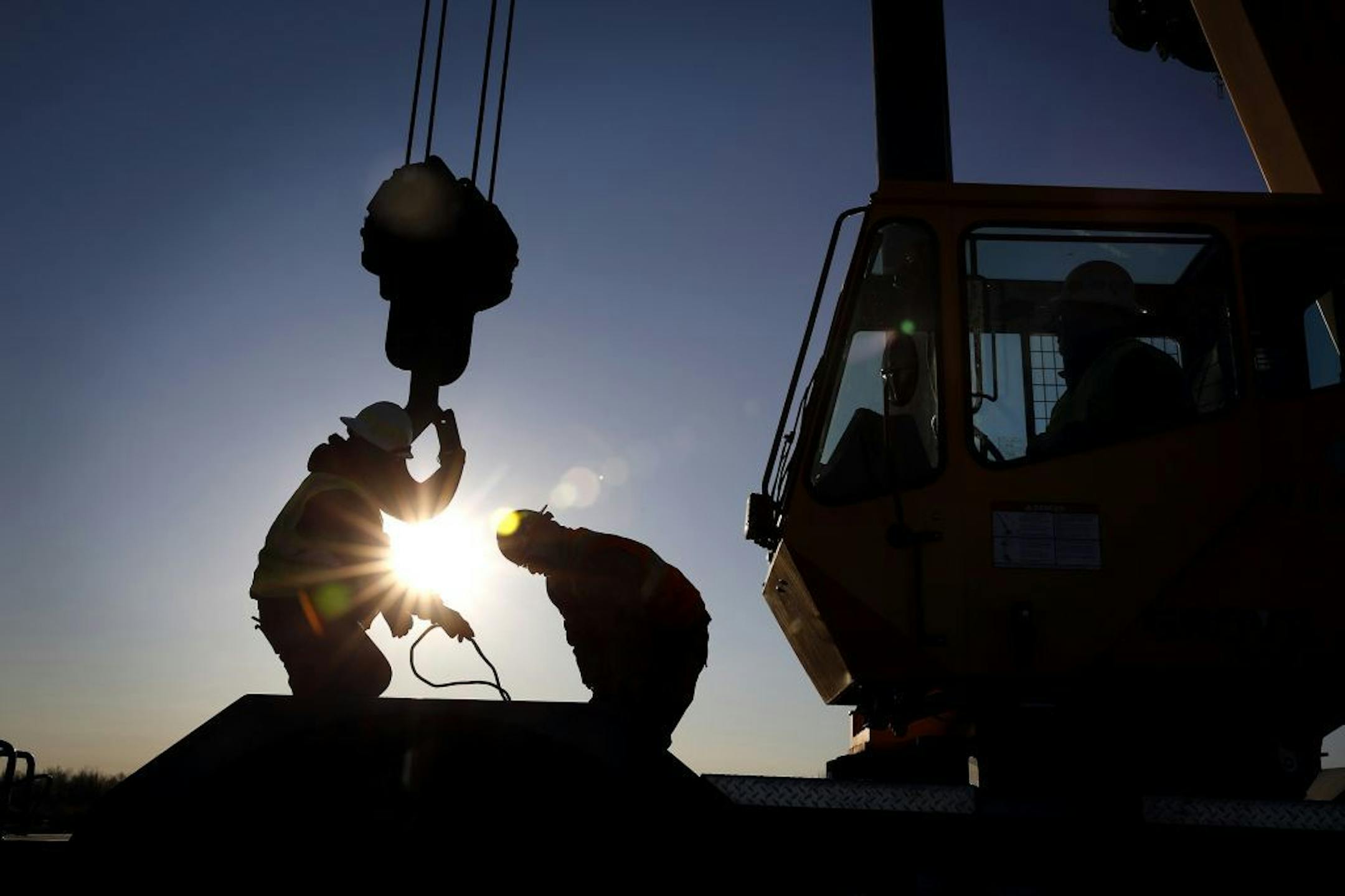 Iron workers set up a crane to move steel for the construction of buildings on the site of Essar Steel Minnesota's taconite mine project in Nashwauk, Minn.