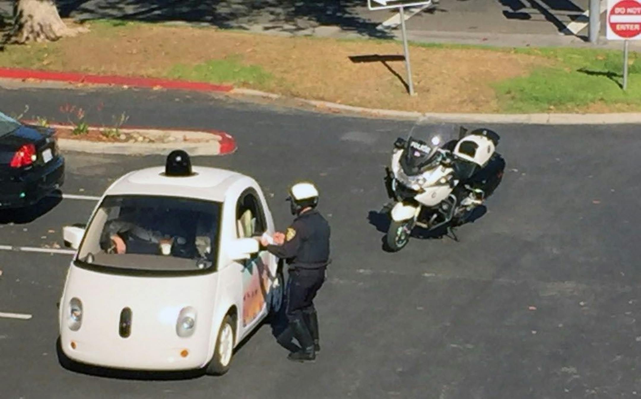 In this Thursday, Nov. 12, 2015 photo provided by Zandr Milewski, a California police officer pulls over a self-driving car specially designed by Google that was being tested on a local road in Mountain View, Calif. The police officer saw the car going a road-clogging 24 mph in a 35 mph zone and realized it was a Google Autonomous Vehicle. After getting closer to it he noticed that there was no one actually driving the car. The officer stopped the car and contacted the person�behind the wheel to