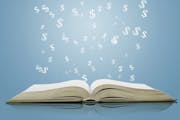 Open book with cloud and falling dollar sign over blue background