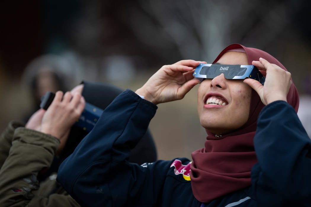 Yasmeen Iman uses her protective glasses Monday to try to see the eclipse at 2 p.m., at the Bell Museum, but it was completely obscured by clouds. The museum hosted the event for Minnesota’s partial view of the eclipse and to monitor it in other parts of the world.