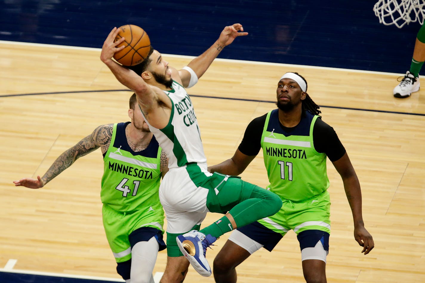 Boston Celtics forward Jayson Tatum (0) shoots against Minnesota Timberwolves forward Juancho Hernangomez (41) and center Naz Reid (11) in the third quarter during an NBA basketball game, Saturday, May 15, 2021, in Minneapolis. (AP Photo/Andy Clayton-King)