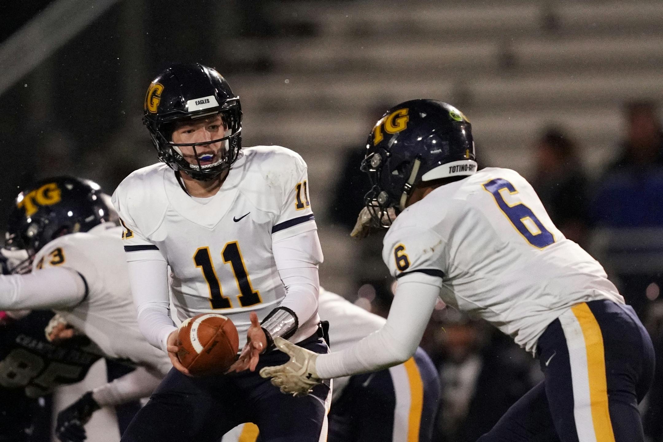 Totino-Grace quarterback Kristoff Kowalkwoski handed the ball off to Totino-Grace fullback Isiah Traufler.
