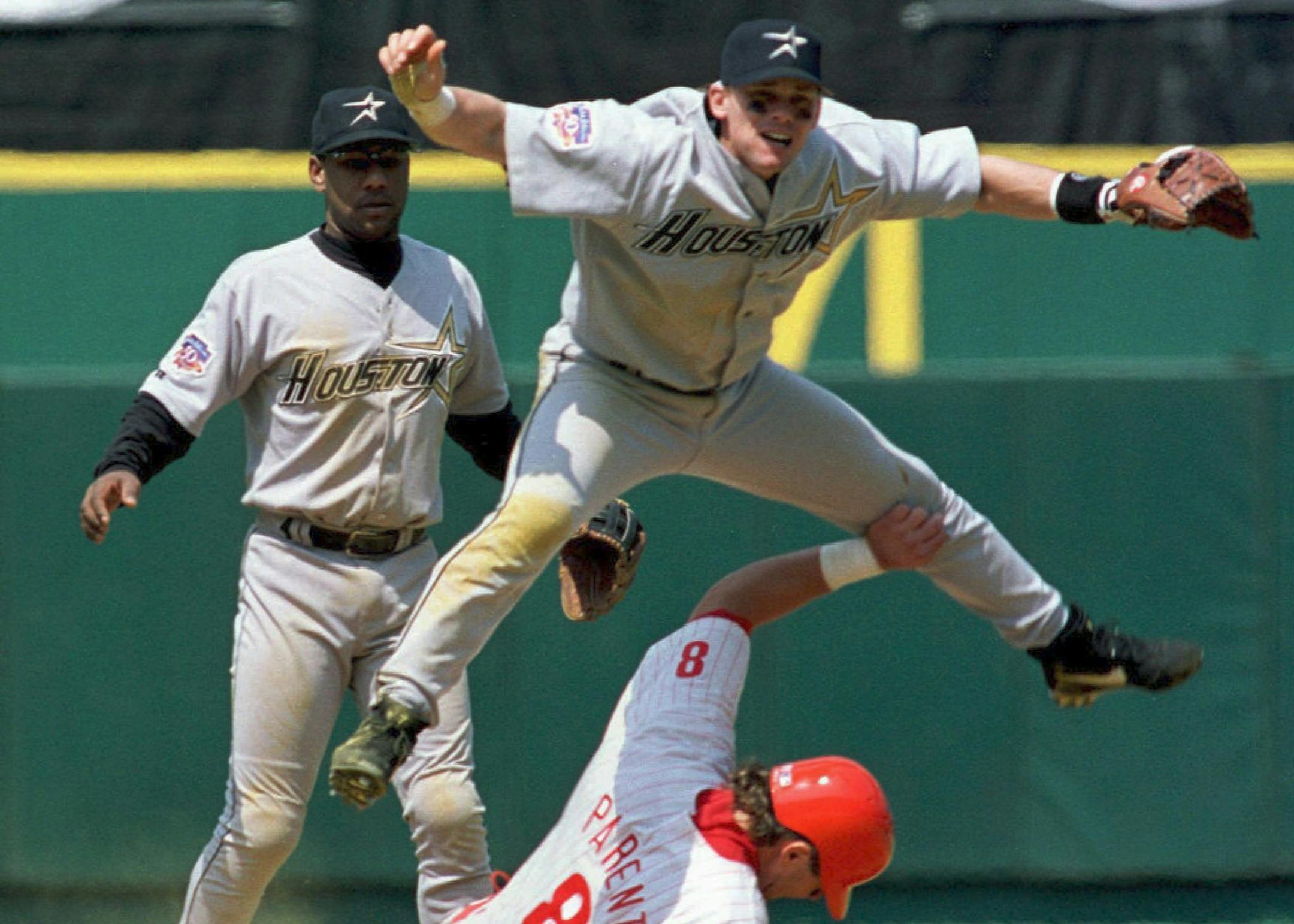 Houston Astros second baseman Craig Biggio (C) leaps over the sliding Philadelphia Phillies Mark Parent who advanced on a grounder by teammate Kevin Stocker in the fourth inning of play, 18 May in Philadelphia. Looking on is Astros shortstop Ricky Gutierrez. The Phillies won 5-2. AFP PHOTO/TOM MIHALEK ORG XMIT: MIN2014010818583780