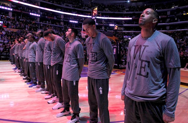 Minnesota Timberwolves stand in dedication to Flip Saunders during warmups before an NBA basketball game against the Los Angeles Lakers in Los Angeles