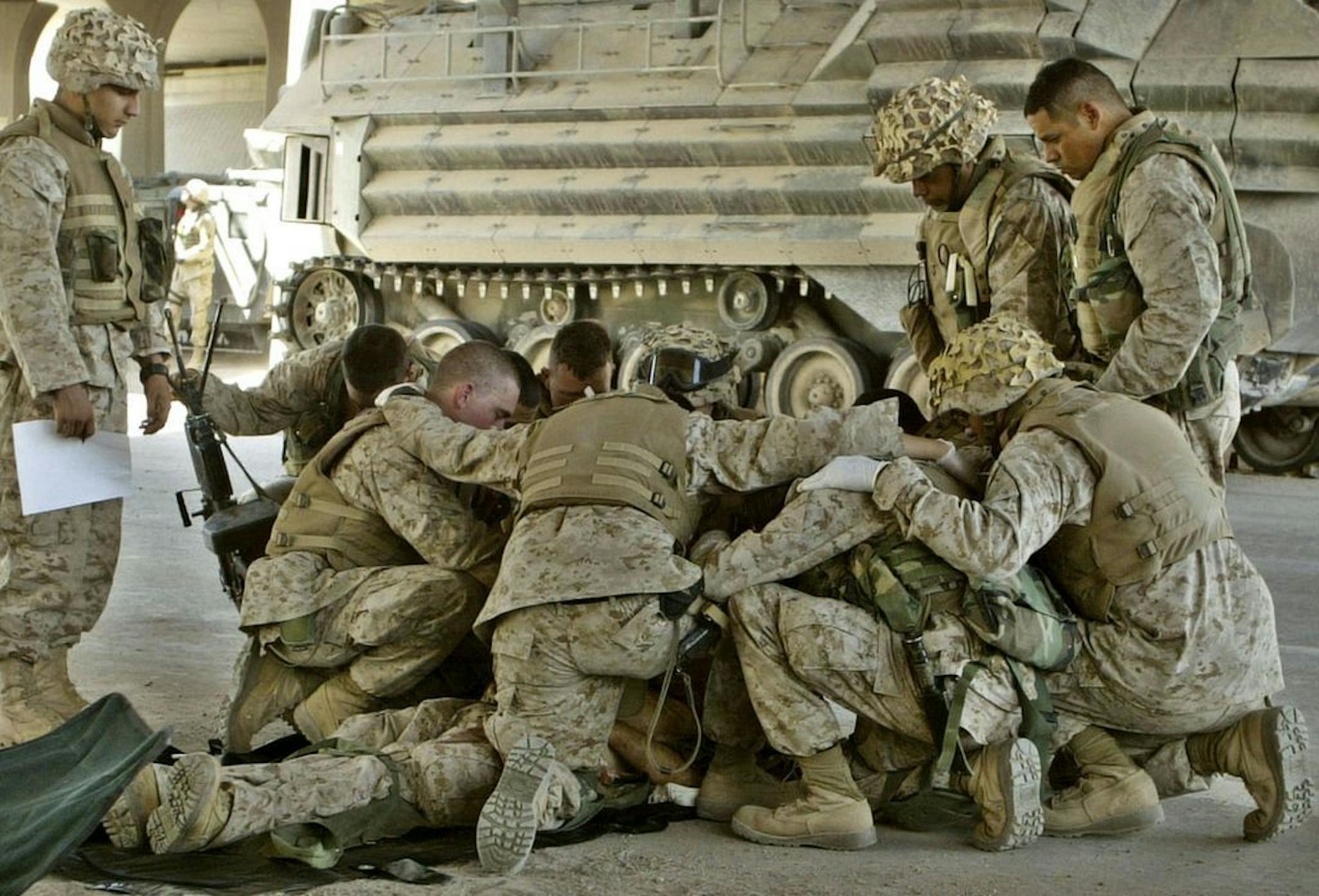 U.S. Marines pray over a fallen comrade at a first aid point after he died from wounds suffered in fighting in Fallujah, Iraq, in this April 8, 2004 file photo.