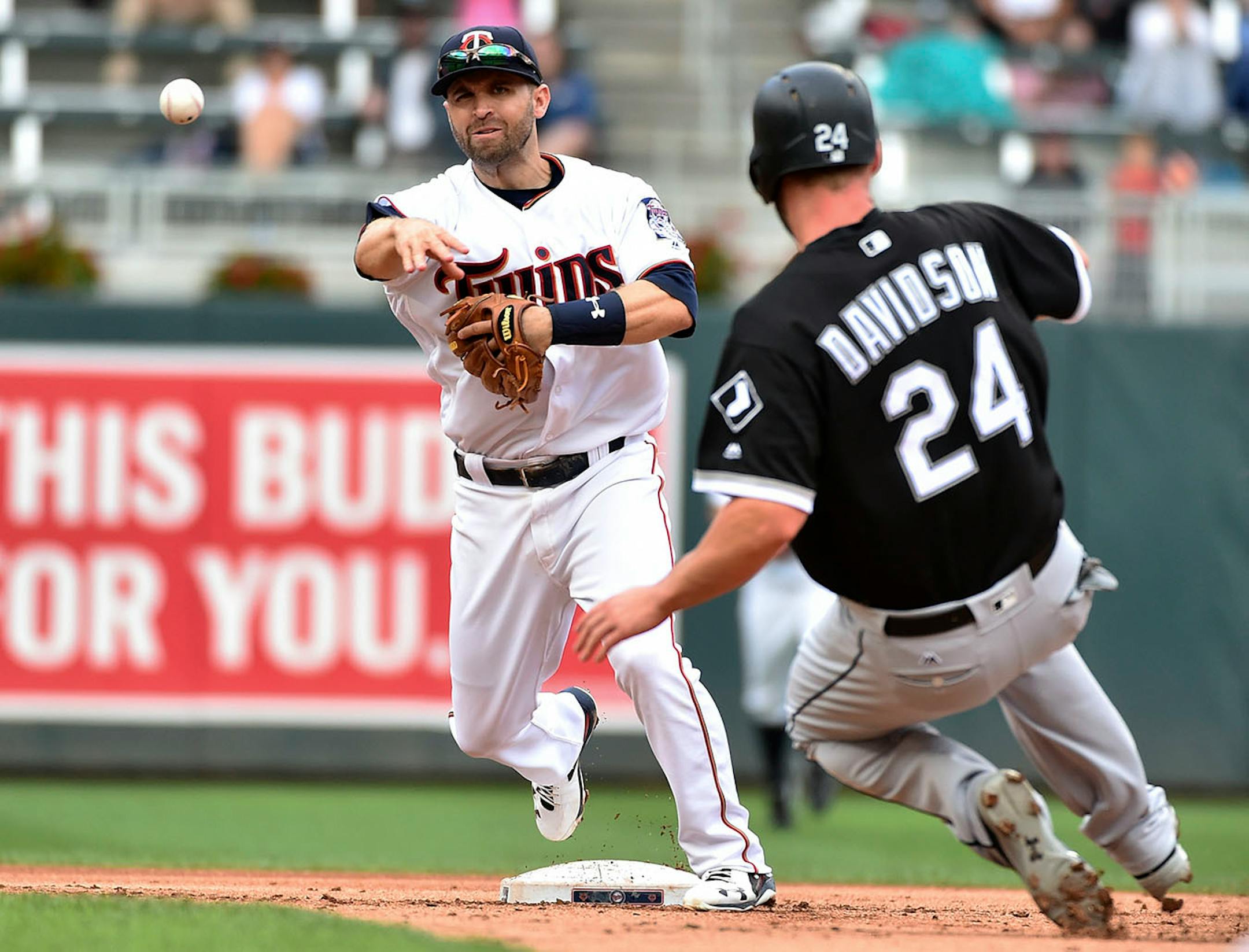 Minnesota Twins second baseman Brian Dozier fires the ball to first in an unsuccessful double play attempt after for the force out of Chicago White Sox's Matt Davidson during the first inning of a baseball game, Thursday, June 22, 2017, in Minneapolis. (AP Photo/John Autey)