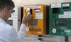 A man uses the Bitcoin ATM in Hong Kong, Friday, May 11, 2018. Bitcoin is the world's most popular virtual currency. Such currencies are not tied to a