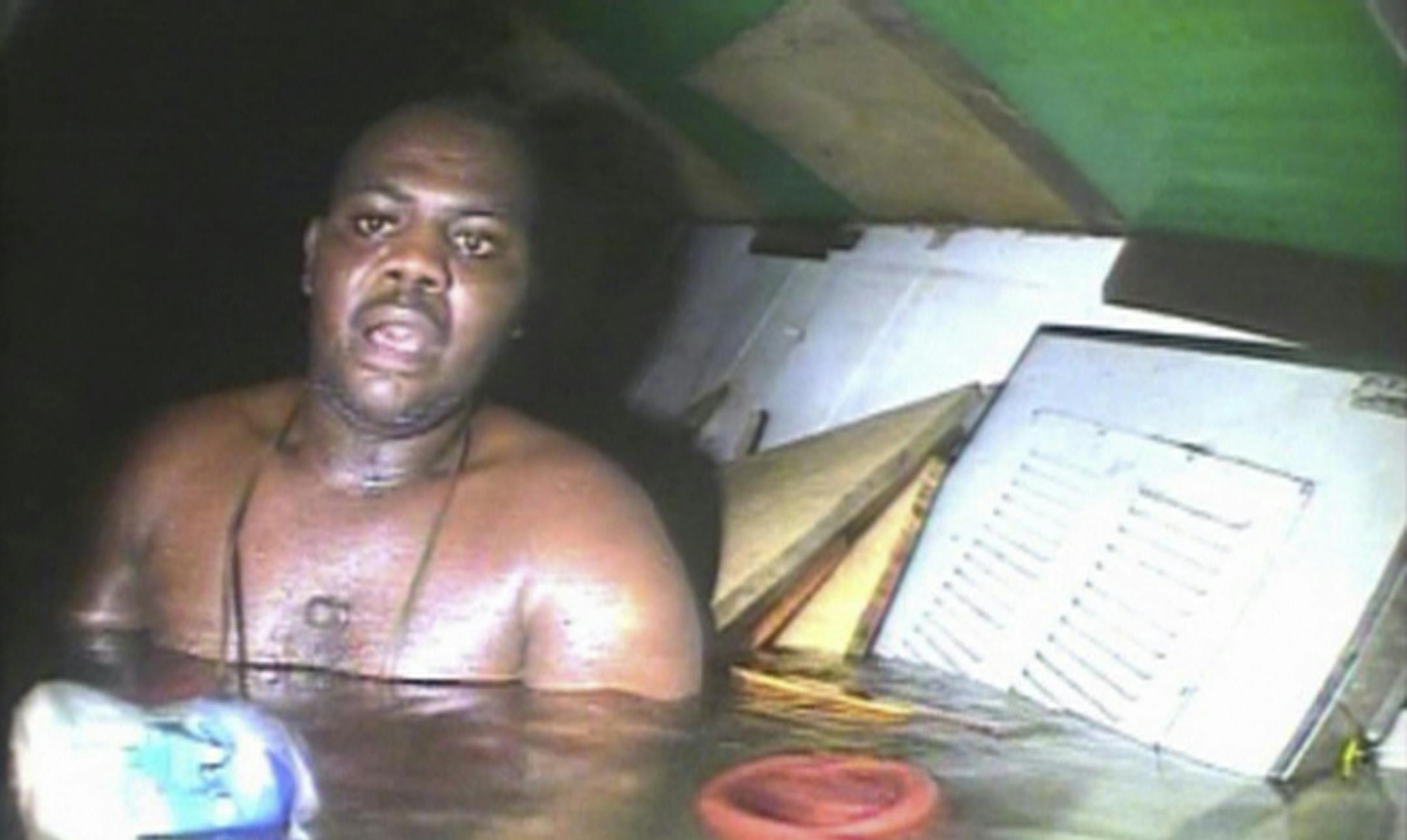 In this image made available Tuesday Dec. 3, 2013, Harrison Odjegba Okene looks in awe as a rescue diver surfaces into the air pocket which has kept Okene alive for nearly three days, recorded by the diver's headcam video the full impact of the miraculous encounter becomes plain the see. Okene was working as a cook aboard a tugboat in the Atlantic Ocean off the Nigerian coast in June 2013, when a heavy swell caused the vessel to capsize and his boat sank to the sea bed, where his 11 colleagues d