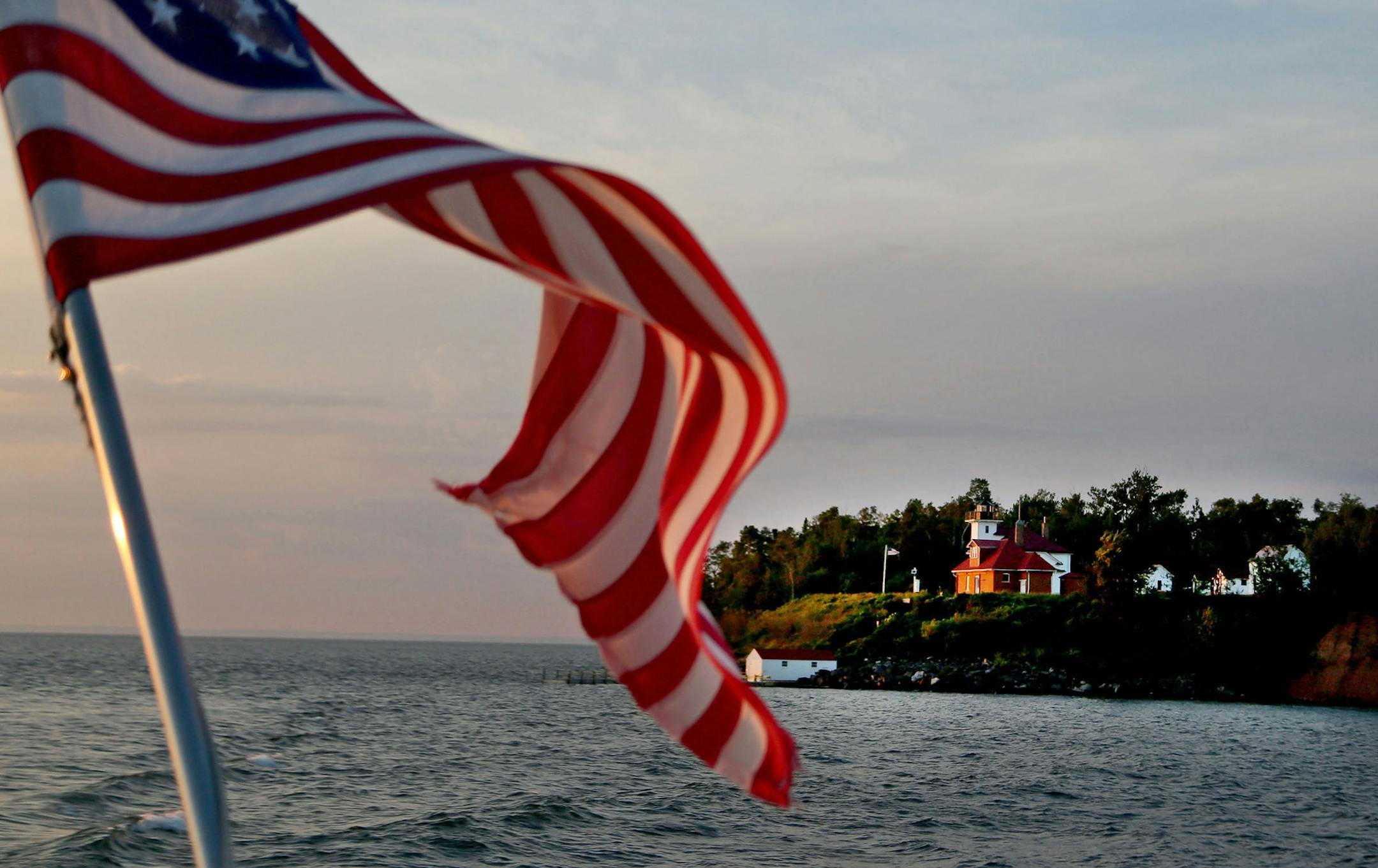 The Superior Princess coasts by the Raspberry Lighthouse and its house for the lighthouse keeper. By David Joles