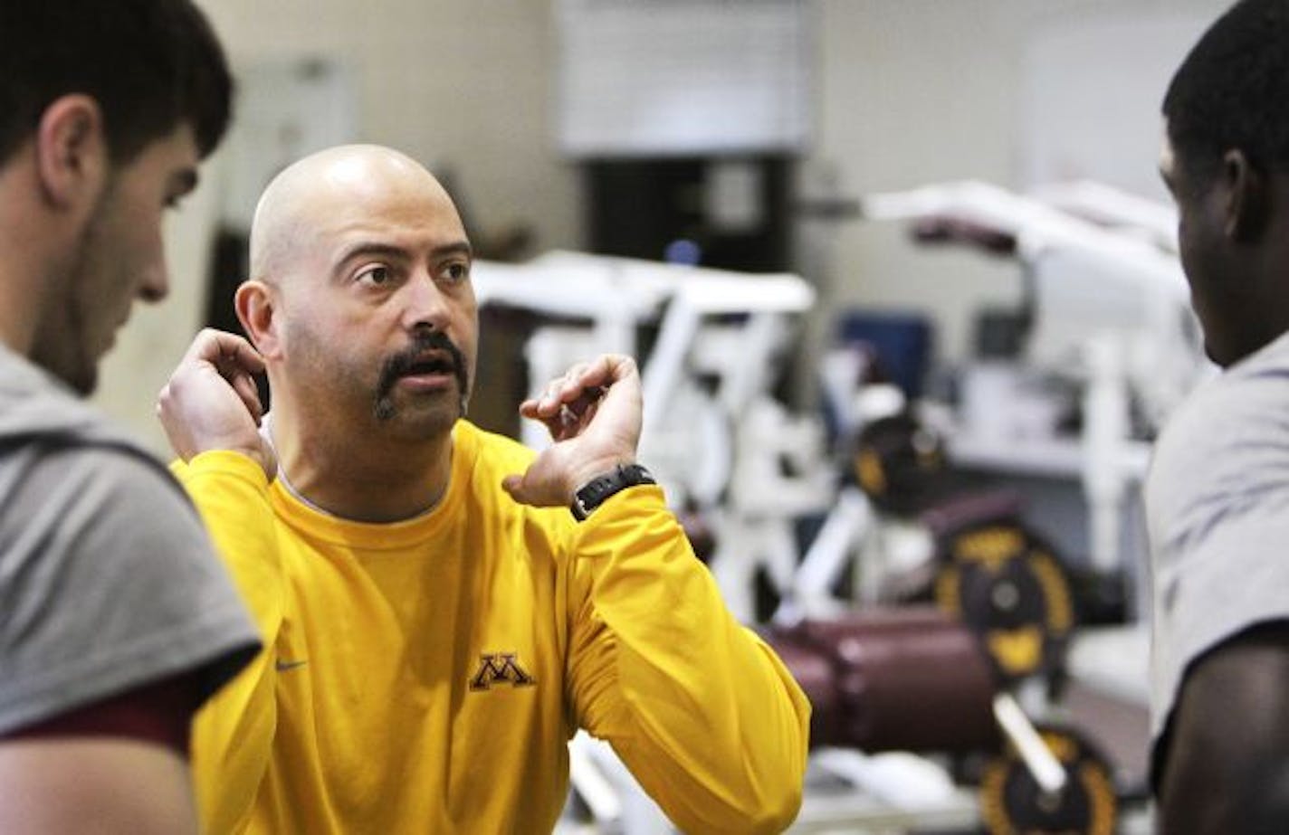 Gophers football strength and conditioning coach Eric Klein (center)