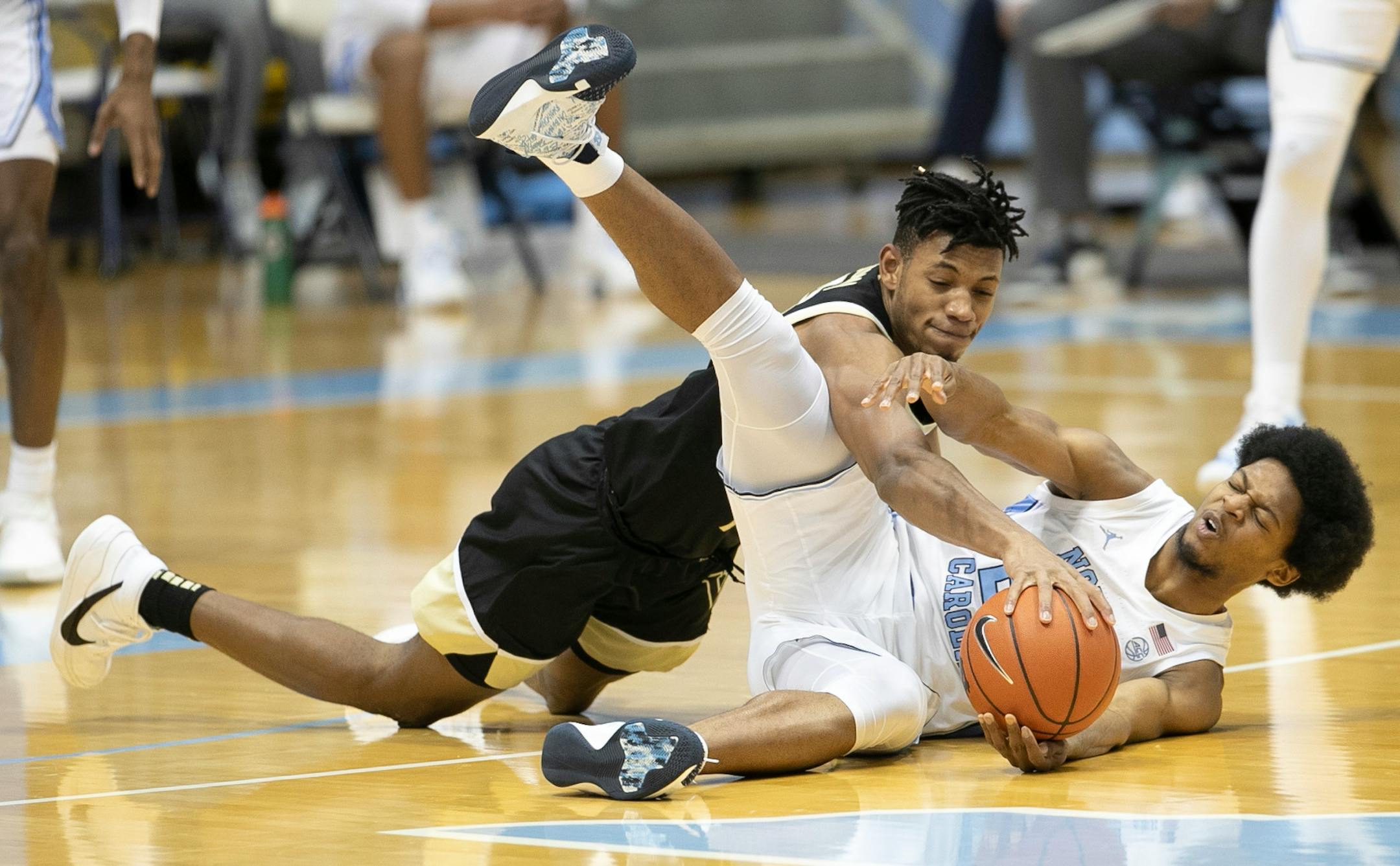 North Carolina's Kerwin Walton, right, and Wake Forest's Ody Oguama (33) vie for the ball during the first half of an NCAA college basketball game Wednesday, Jan. 20, 2021, in Chapel Hill, N.C. (Robert Willett/The News &amp; Observer via AP)