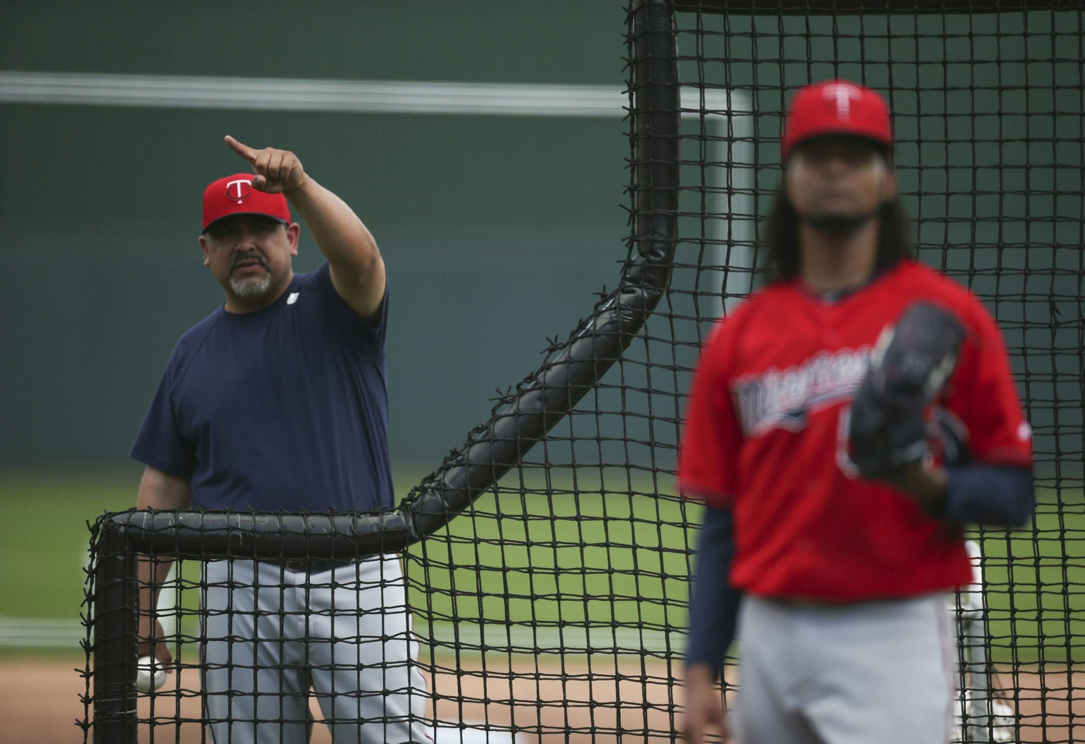Bullpen coach Eddie Guardado signaled that pitcher Ervin Santana, foreground, had reached his pitch count while throwing for batting practice Sunday afternoon at Hammond Stadium.