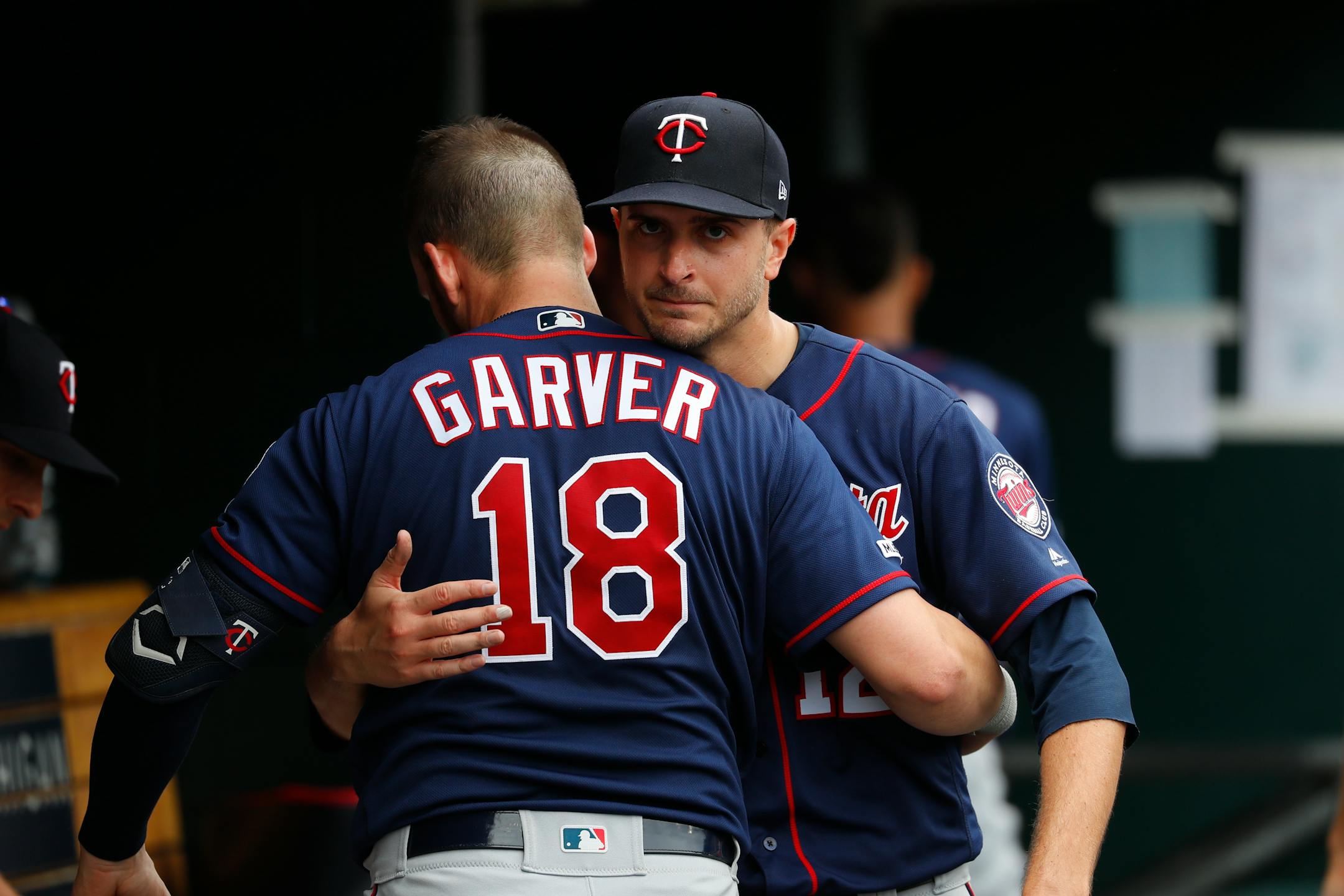 Minnesota Twins pitcher Jake Odorizzi, right, hugs catcher Mitch Garver (18) in the dugout in the sixth inning of a baseball game against the Detroit Tigers in Detroit, Sunday, June 9, 2019. (AP Photo/Paul Sancya)