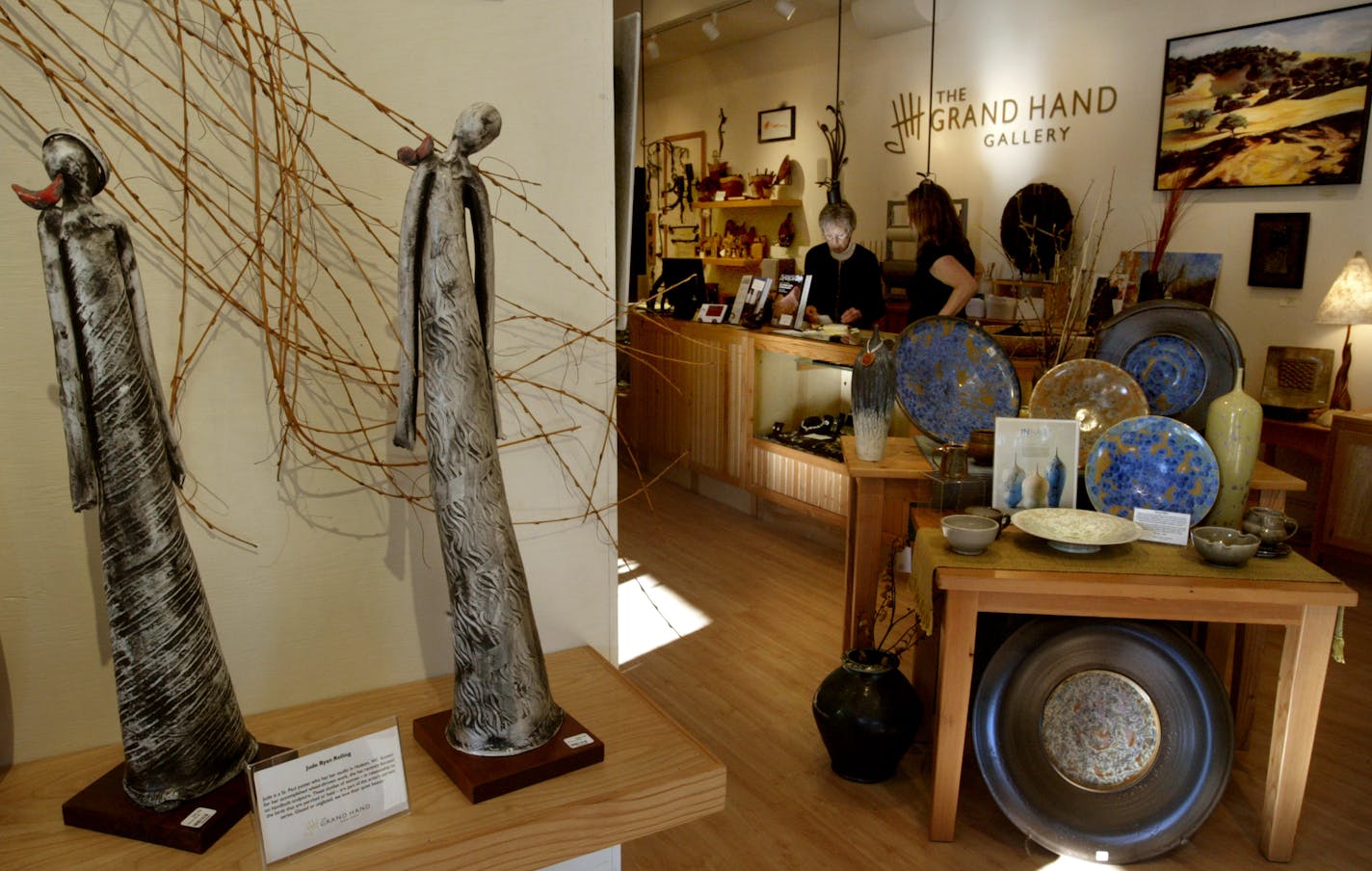 Work at the Grand Hand Gallery in St. Paul, which recently expanded by teaming up with River Gallery frame shop next door, includes pieces by area artists Jude Ryan Reiling, left, and Ernest Miller.