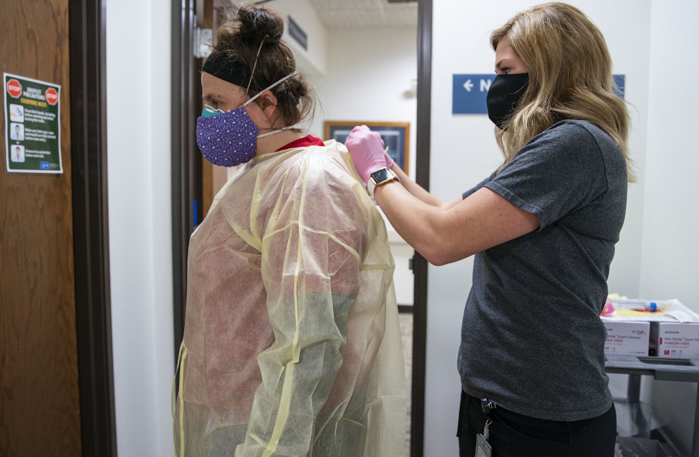 Beth Thomsen was suited up with full-body PPE by Noel Salo before going into an exam room to administer flu, COVID-19 and RSV tests to a 2-month-old child at Min No Aya Win clinic in Cloquet, Minn.