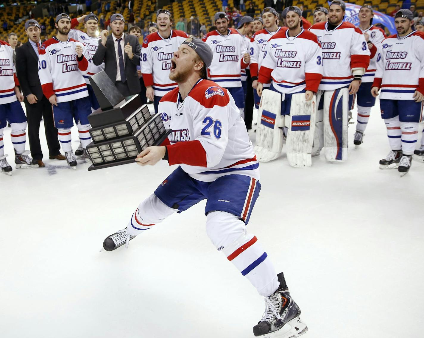 Massachusetts-Lowell's Christian Folin (26) holds the trophy after Lowell defeated New Hampshire 4-0 in the Hockey East championship game in Boston, Saturday, March 22, 2014. (AP Photo/Michael Dwyer)