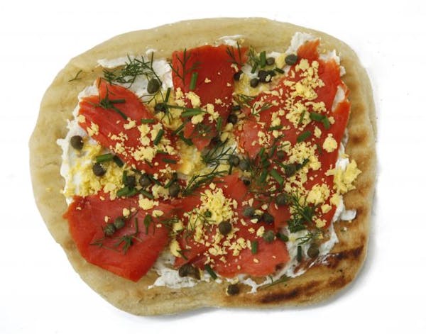 Pizza topped with cream cheese, smoked salmon, hard-cooked egg yolks, fresh dill and capers.