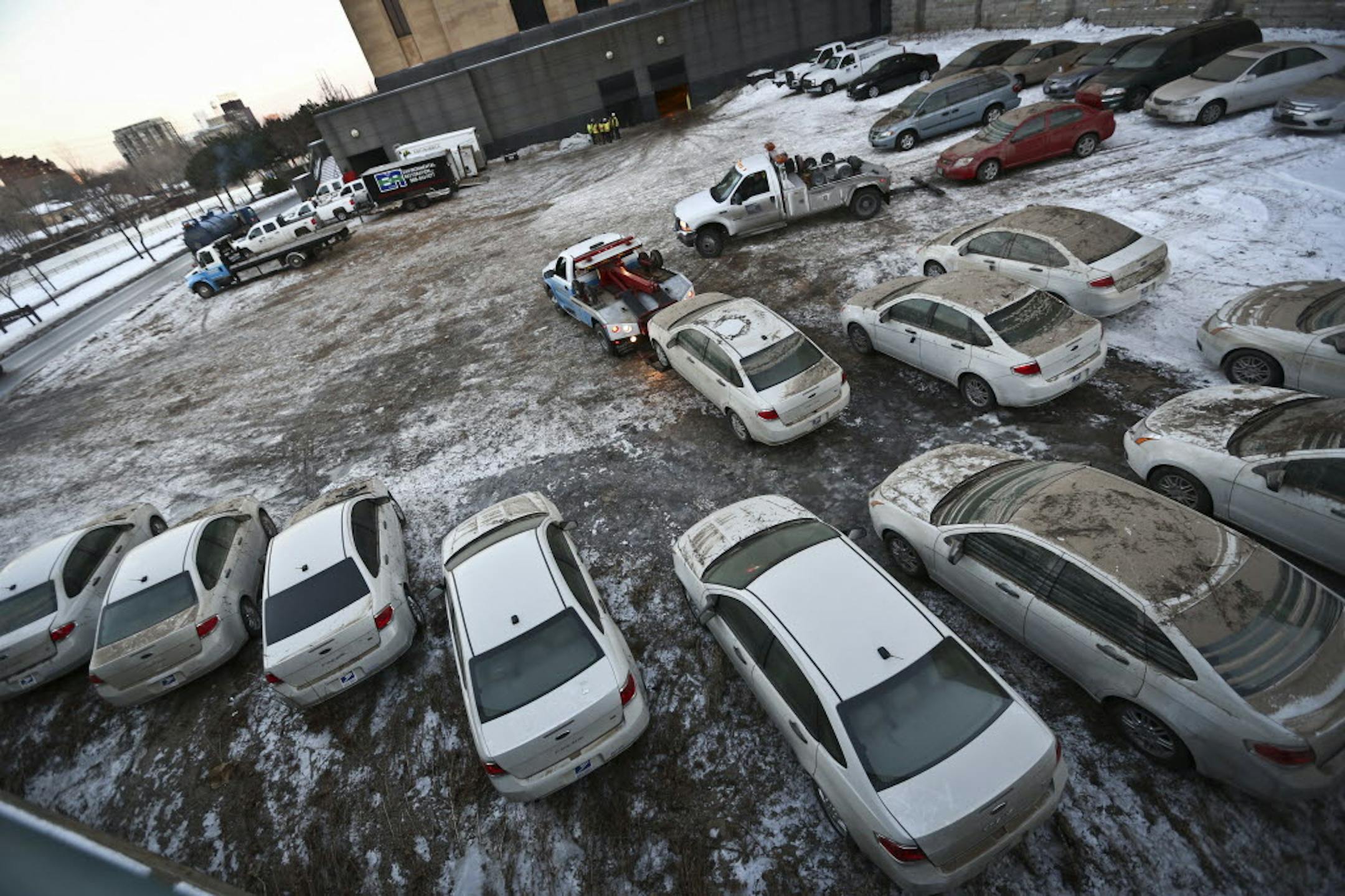 A tow truck removed cars that were damaged when water flooded a below-ground Post Office garage in downtown Minneapolis.