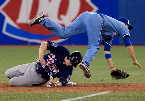 Twins first baseman Justin Morneau still has lingering concussion symptoms from this collision in Toronto on July 7.