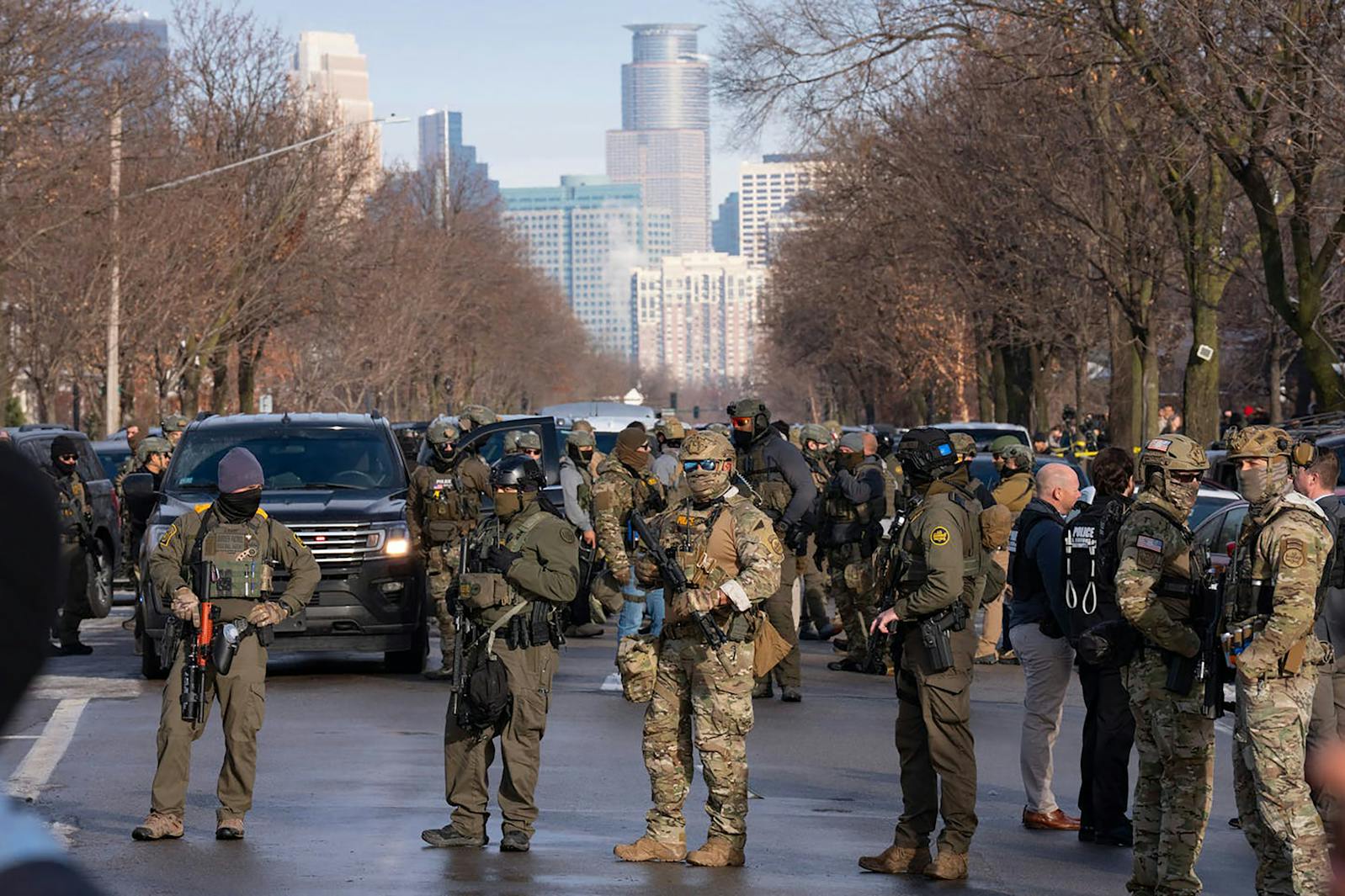 Federal immigration agents stand with weapons drawn along Portland Avenue in Minneapolis on Jan. 7,  near the scene of Renee Good's killing earlier that day. 