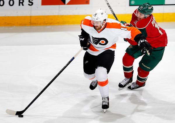 Sean Couturier (14) and Zach Parise (11) fought for the puck during a game last season.