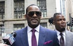 FILE - This March 13, 2019 file photo shows R. Kelly and his publicist Darryll Johnson, right, leaving The Daley Center after an appearance in court f
