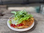 Crispy crêpes stuffed with bean sprouts are fried up to order and served with a pile of fresh herbs at Banh Sizzle's stand at the Mill City Farmers M
