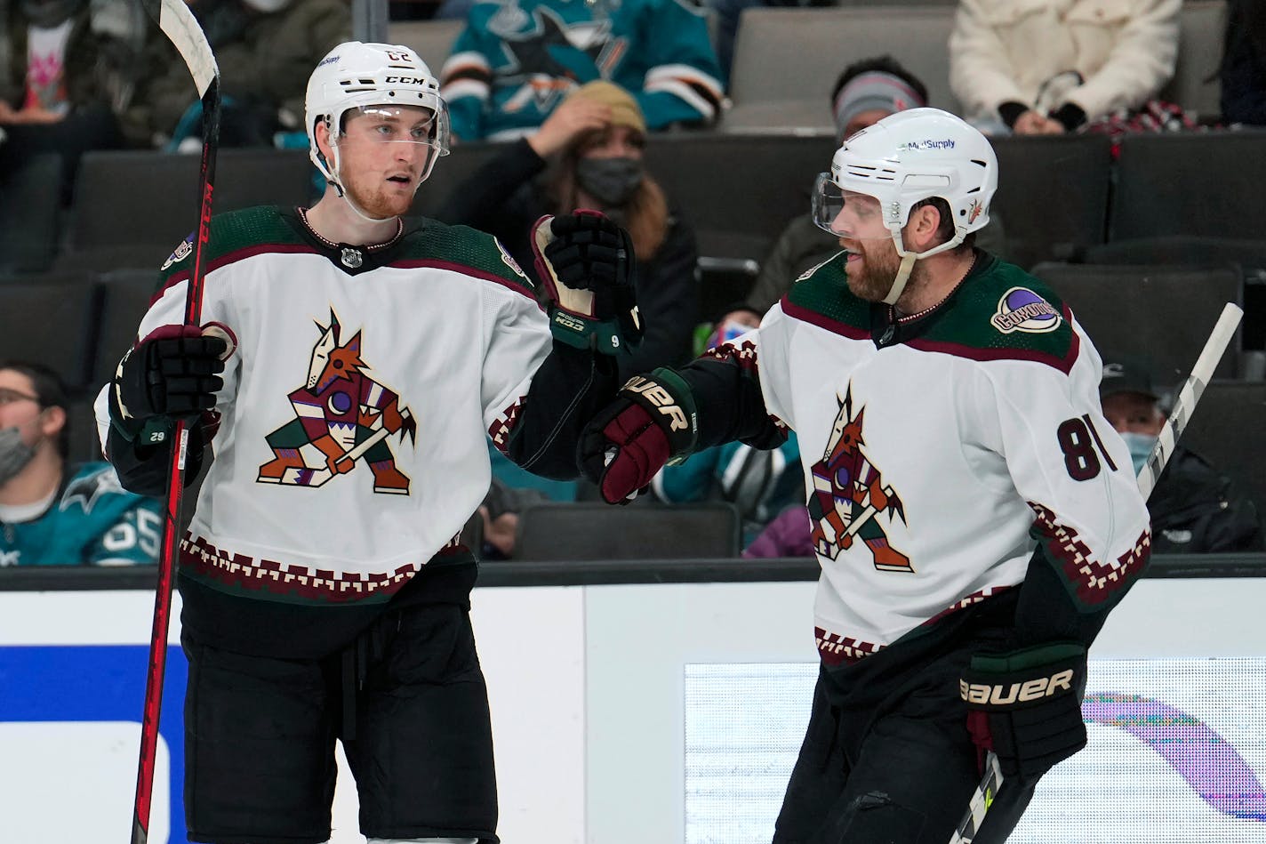 Arizona Coyotes defenseman Janis Moser, left, is congratulated by Phil Kessel (81) after scoring a goal against the San Jose Sharks during the second period of an NHL hockey game Tuesday, Dec. 28, 2021, in San Jose, Calif. (AP Photo/Tony Avelar)