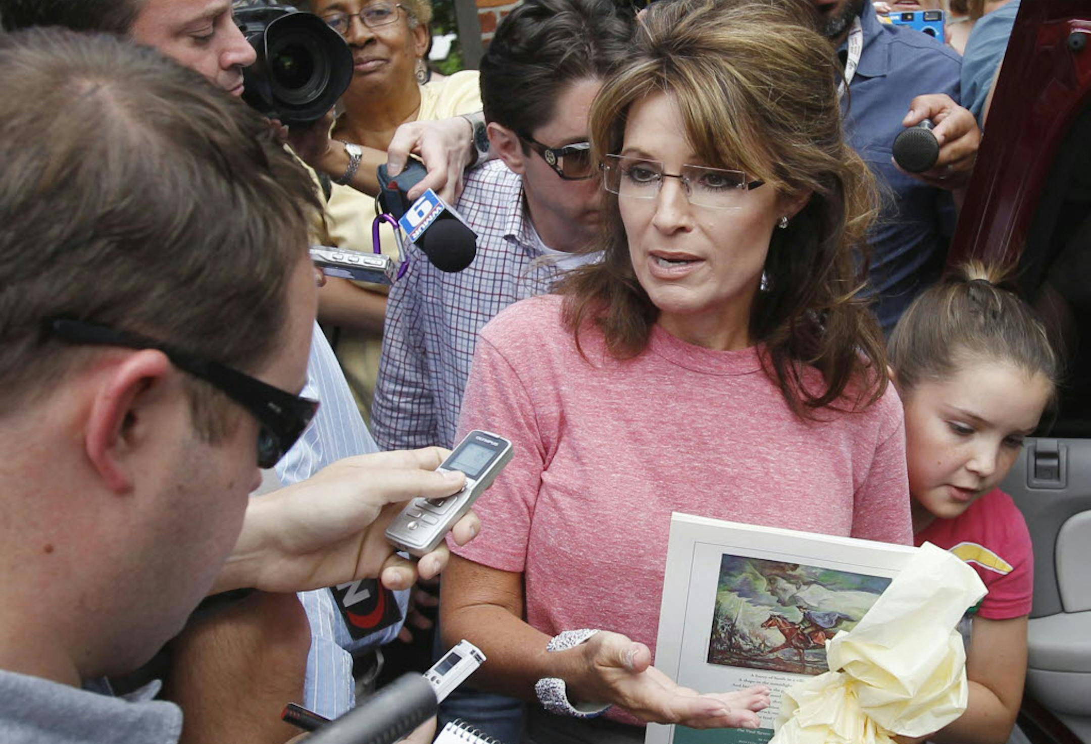 Sarah Palin, holding a booklet depicting Paul Revere, speaks briefly with the media as she tours Boston's North End neighborhood on June 2.