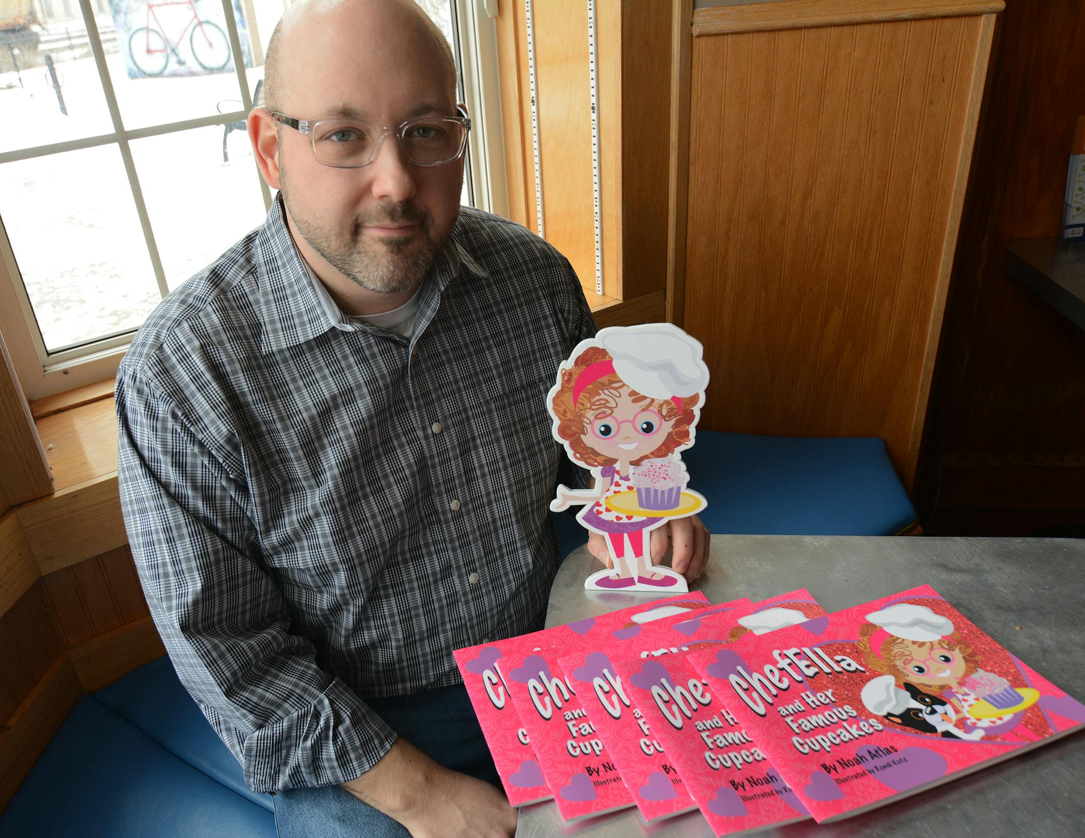 Noah Atlas, director of Anoka Hennepinís Child Nutrition Program, shows off his book that encourages cooking with whole foods and healthy ingredients. Liz Rolfsmeier, Special to the Star Tribune
