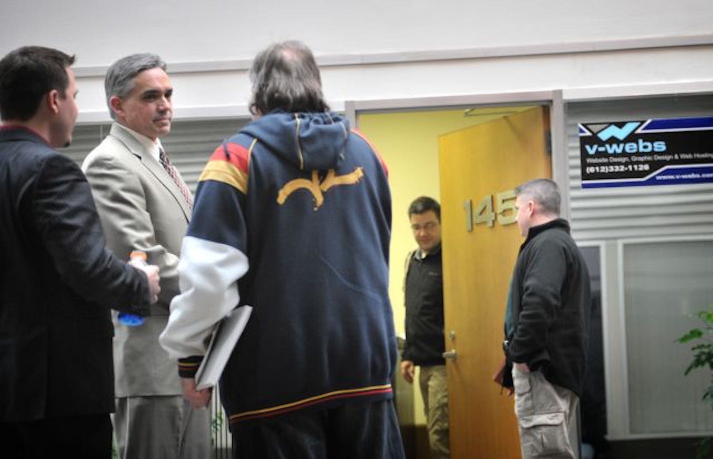 Newly hired Inter-Mark Corp CEO Bob Kinsella, center left, and attorney Mark Kallenbach, center, stood outside iNetGlobal, V-Local and V-Webs offices as Secret Service agents searched for evidence in what authorities are calling a suspected Ponzi scheme.